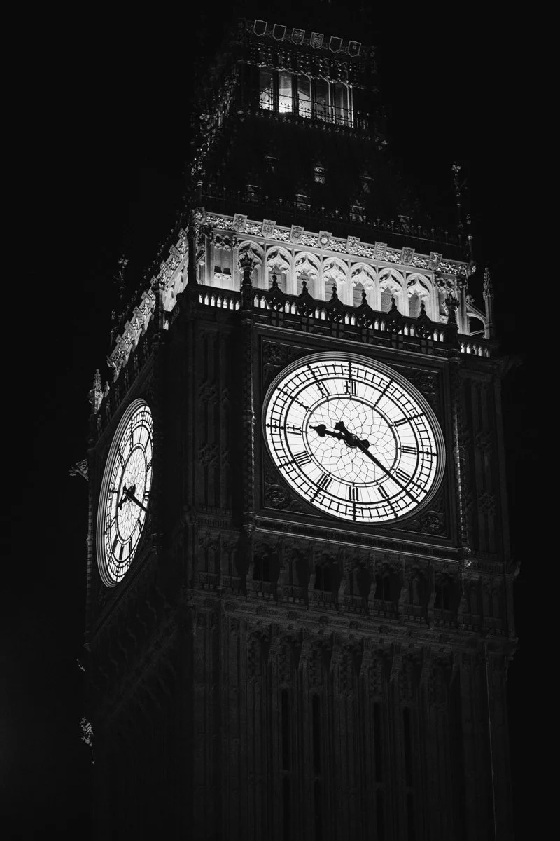 Nighttime black-and-white photo of Big Ben clock tower showing the time as 9:23.