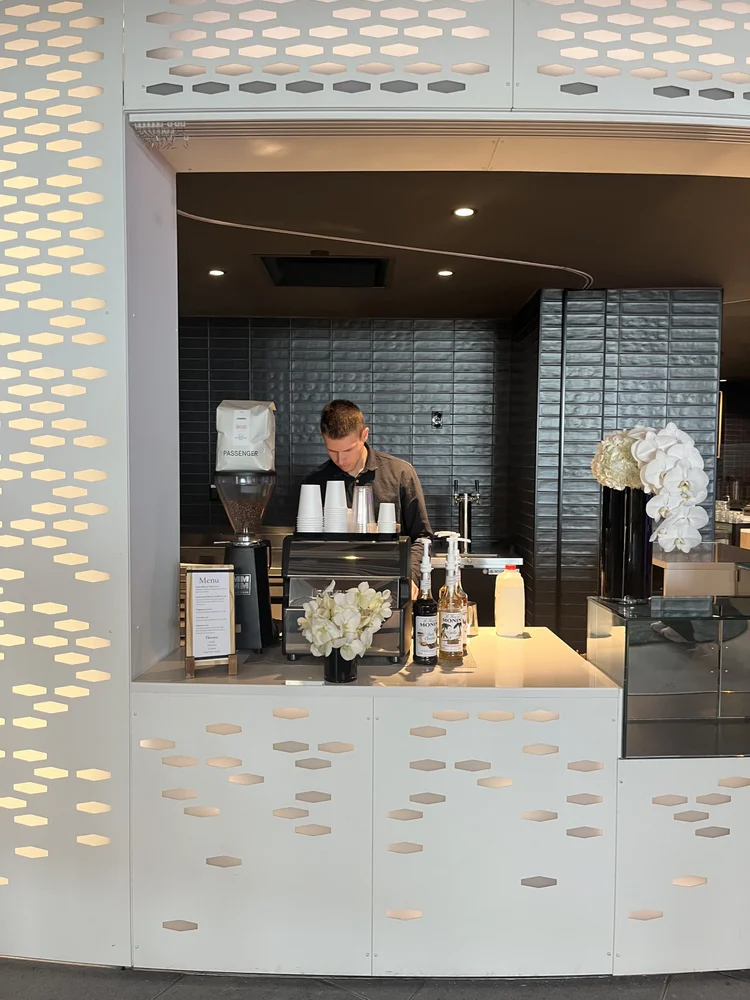 Barista operating an espresso station integrated into a modern venue counter