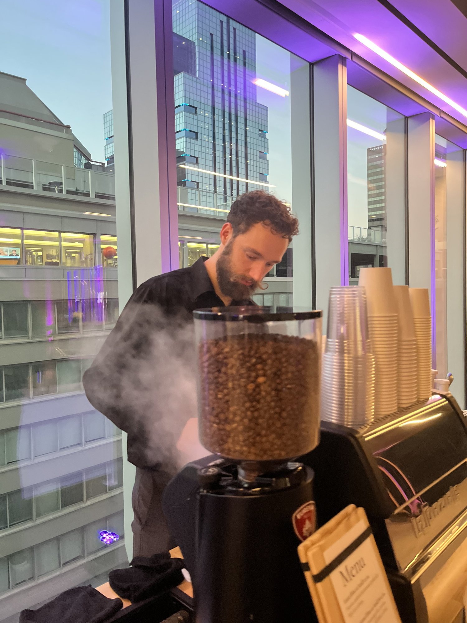 Barista operating a commercial espresso machine at a corporate event
