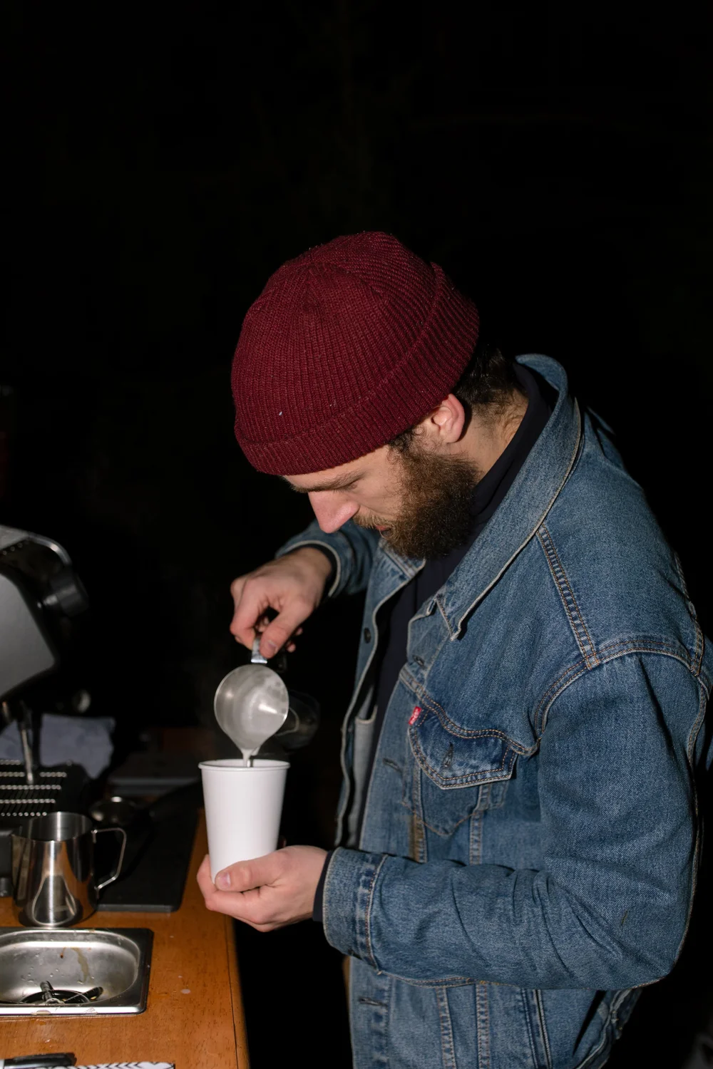 Professional barista pouring steamed milk for a made-to-order latte at a Lancaster event