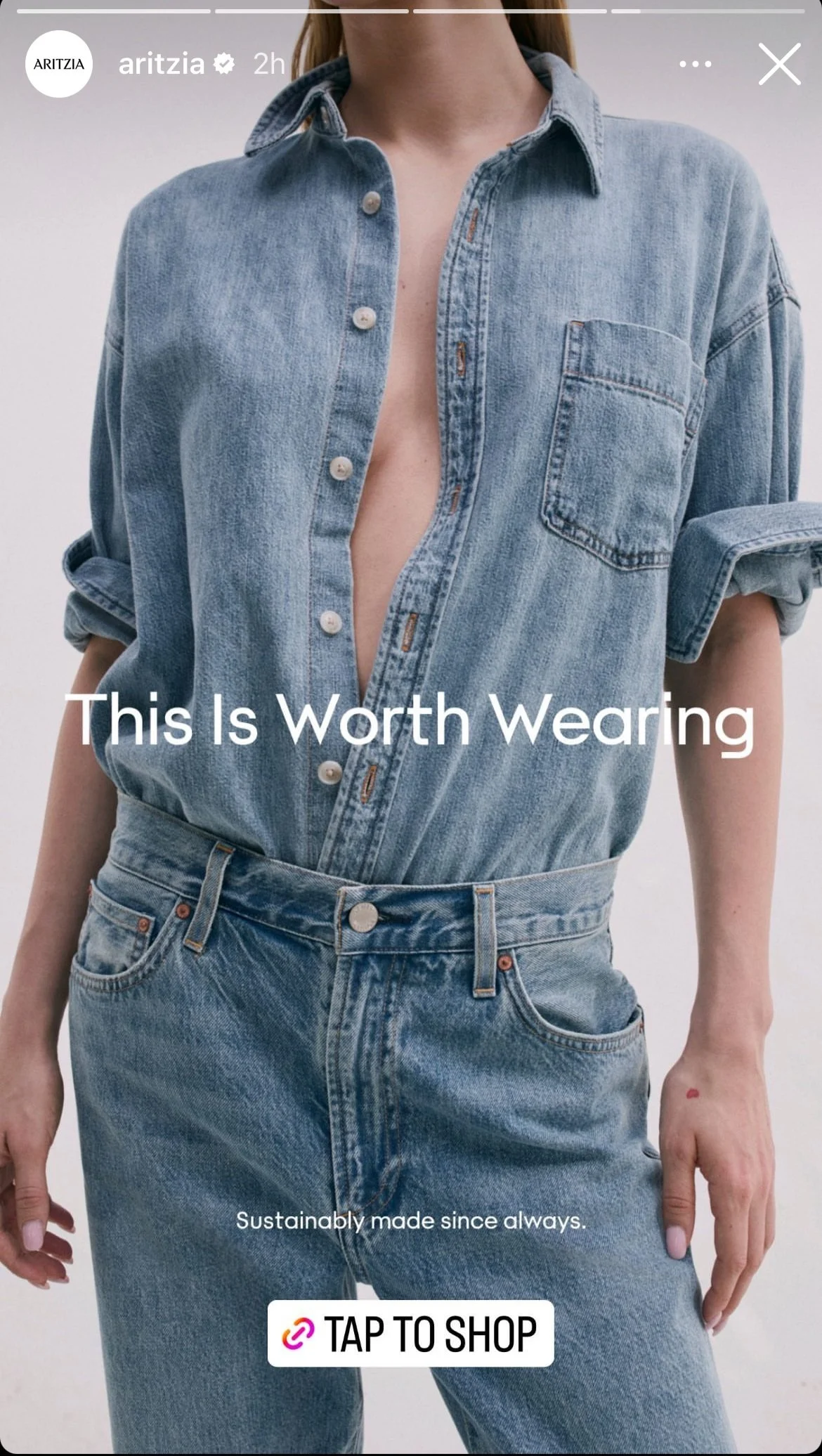Woman wearing a denim shirt and matching jeans, unbuttoned at the top, with a small store logo and a "Tap to Shop" button overlay on the image.