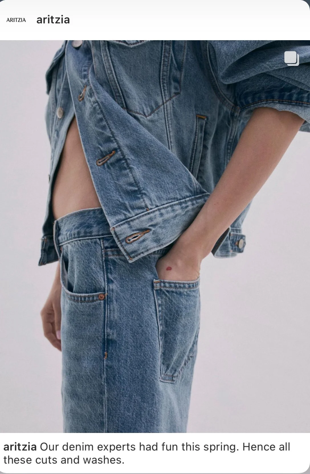 Close-up of a person wearing a denim jacket and jeans, with one hand in their pocket, showing a small red mark on their wrist.