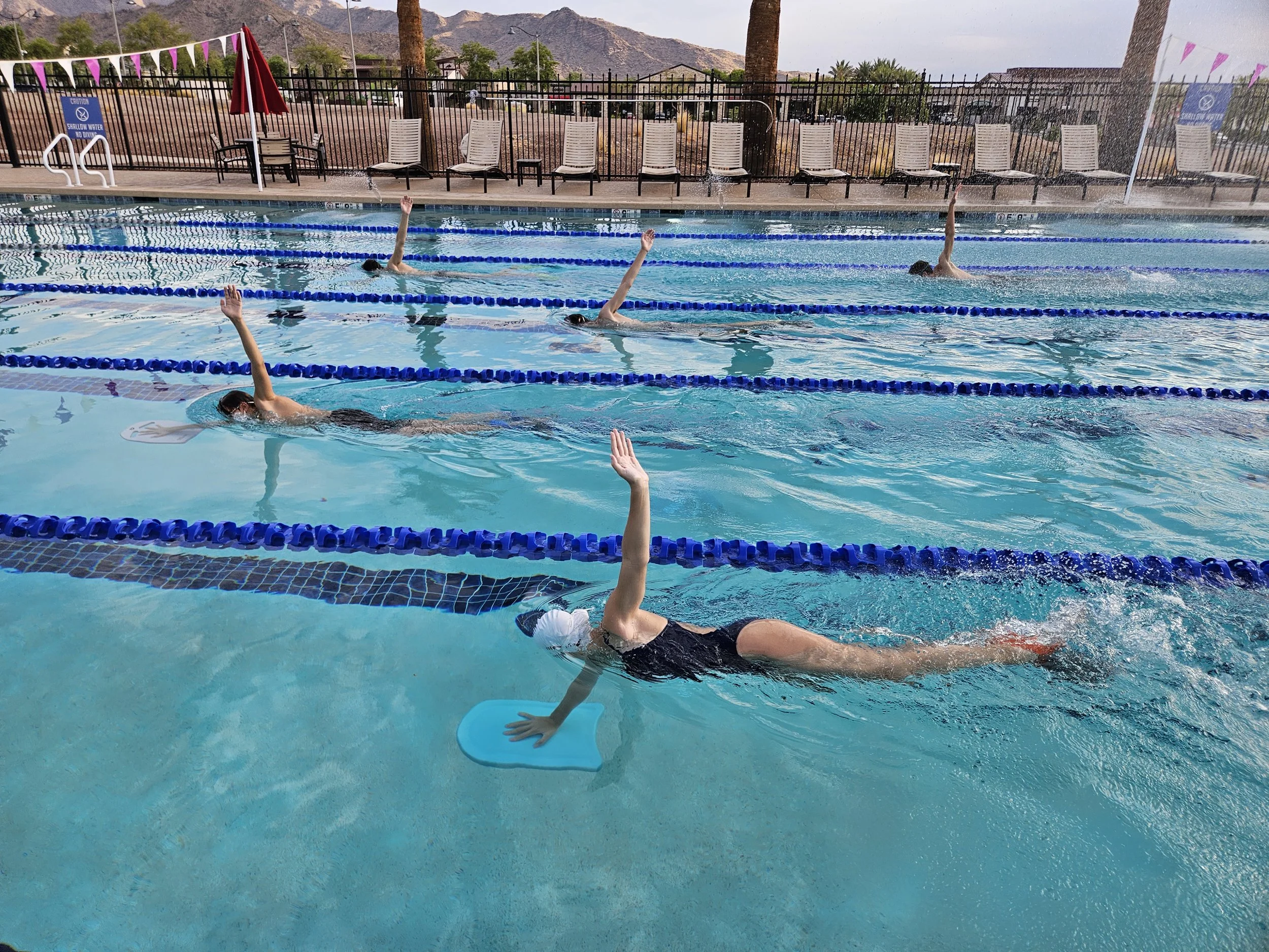 People practicing pool exercises underwater in a swimming pool.