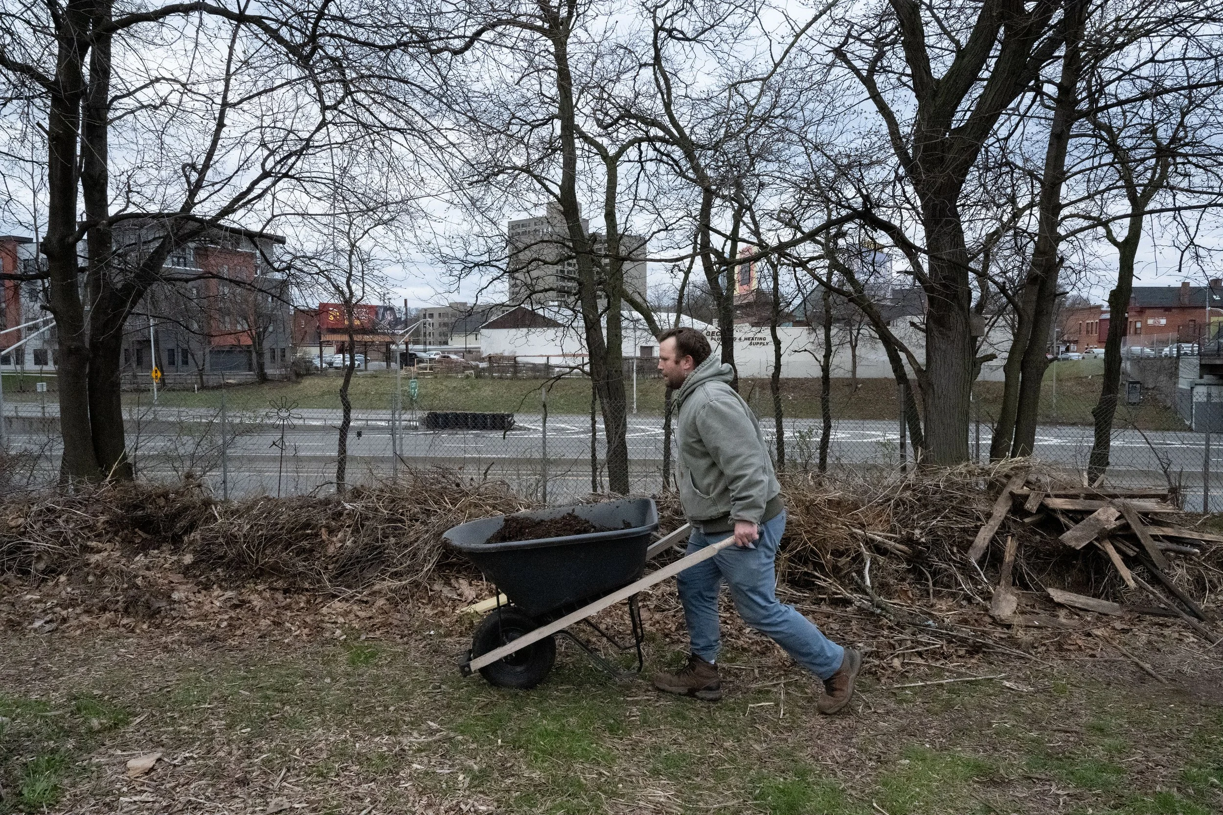 Timothy Dunn wheelbarrows compost from last season at 490 Farm on Monday, April 15, 2024, in Rochester, N.Y. Timothy joined 490 Farm in 2021, “coming together around food really brings everything back to square one”, says Timothy. (Maryel Pryce)