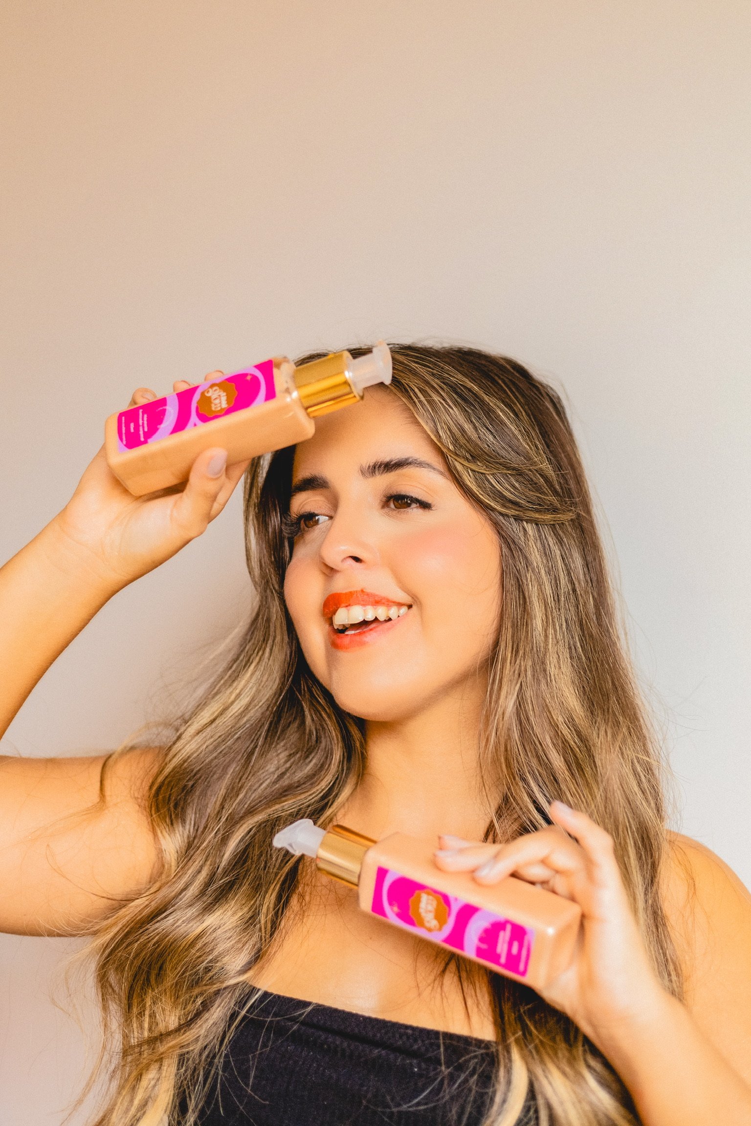 modelo segurando embalagem do hidratante iluminador corporal da marca Libbi