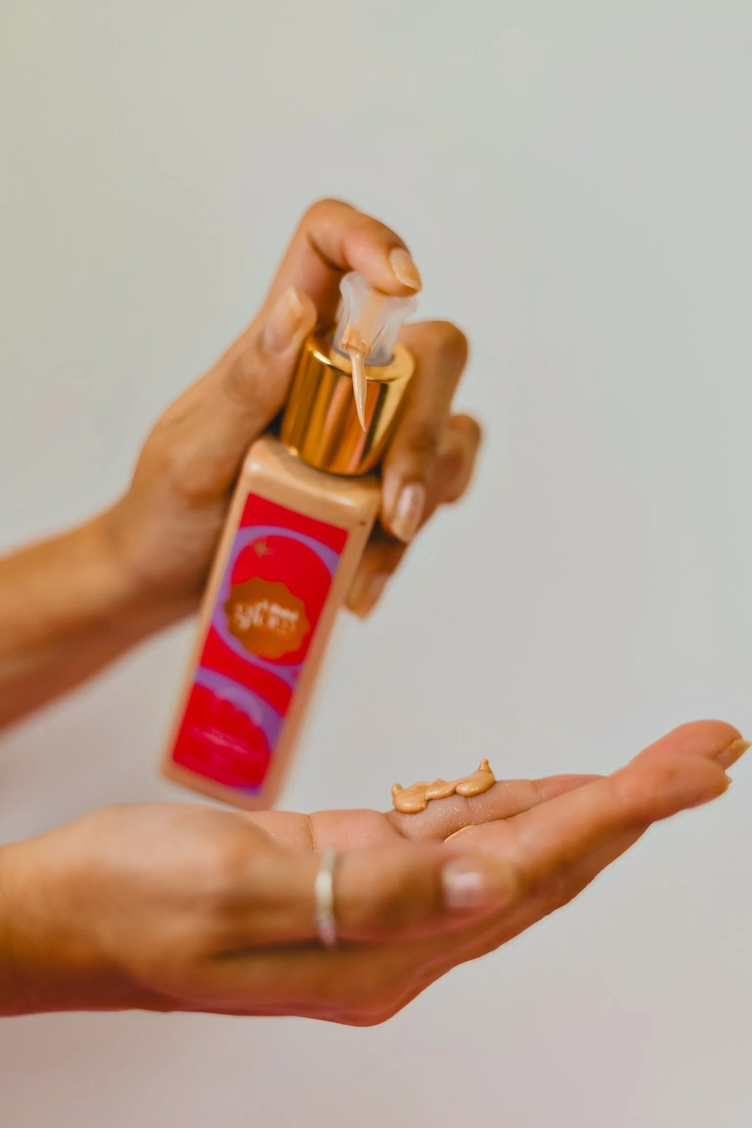 mão segurando embalagem do hidratante iluminador corporal da marca Libbi