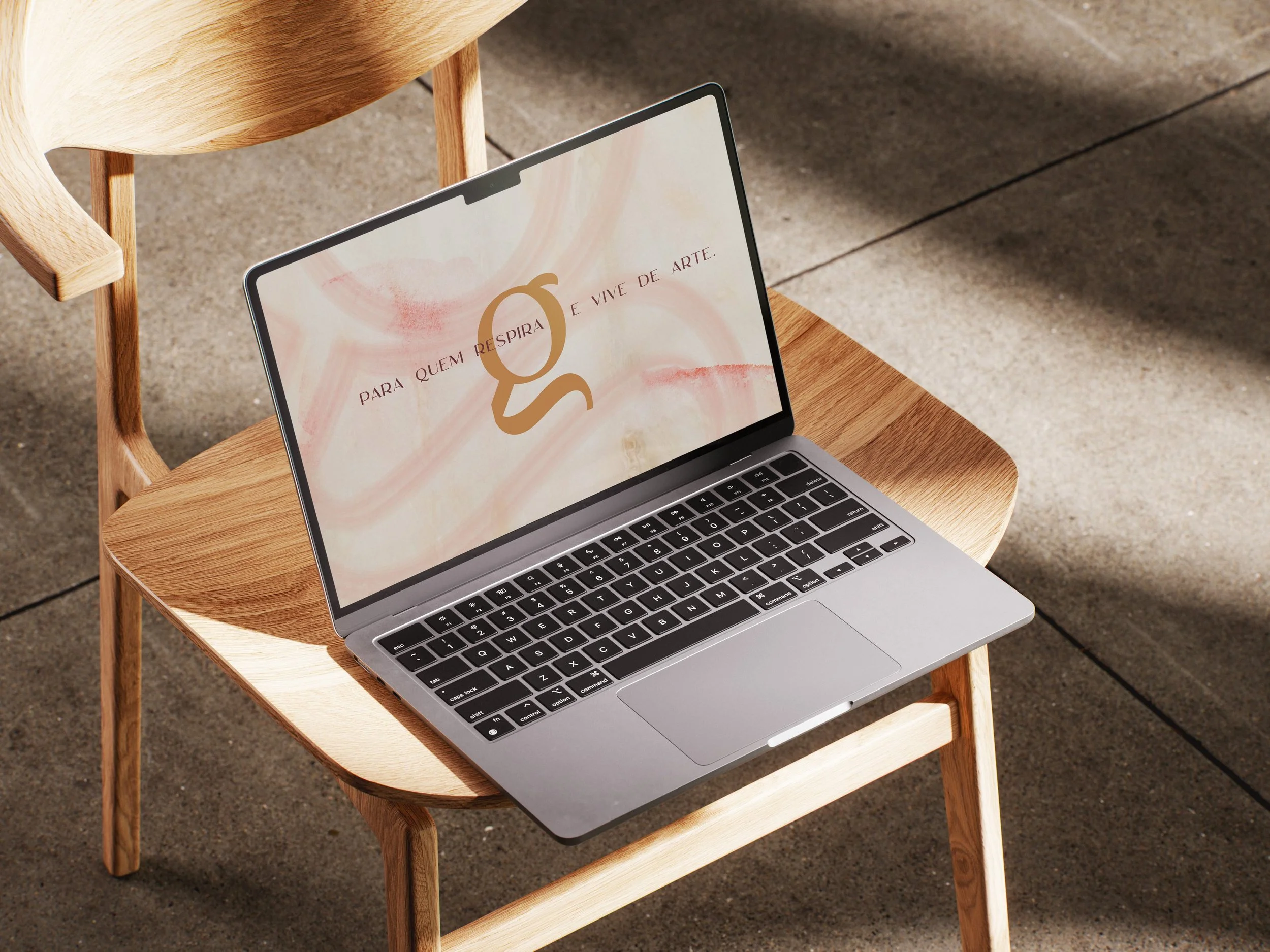 mockup de um notebook com a identidade visual da marca Georgia Graichen como papel de parede.