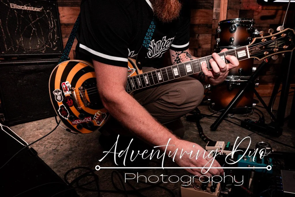 Black Shepard guitarist adjusting the sound controls.