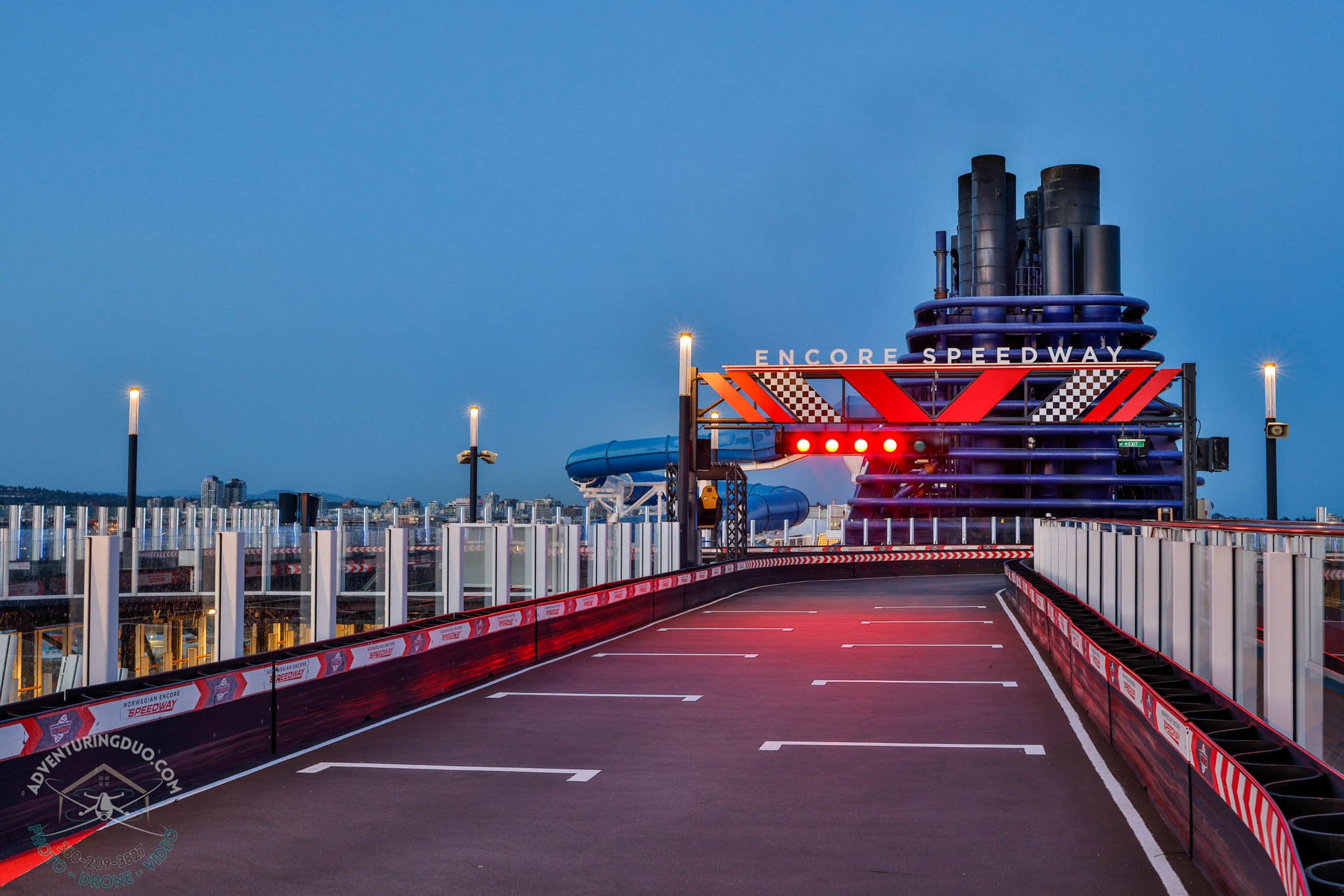 Encore Speedway racetrack with illuminated start line at dusk
Adventuring Duo captures the vibrant design of Norwegian Encore’s go-kart track under a deep blue sky—luxury cruise features in cinematic style.