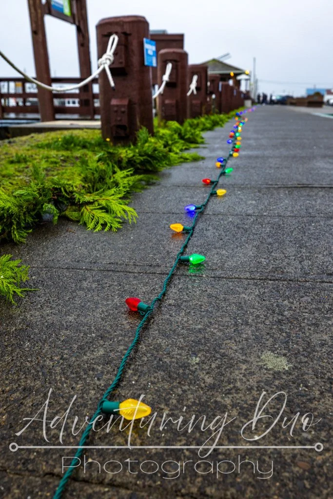 Christmas lights and garland laid on the ground waiting to hung for the holidays