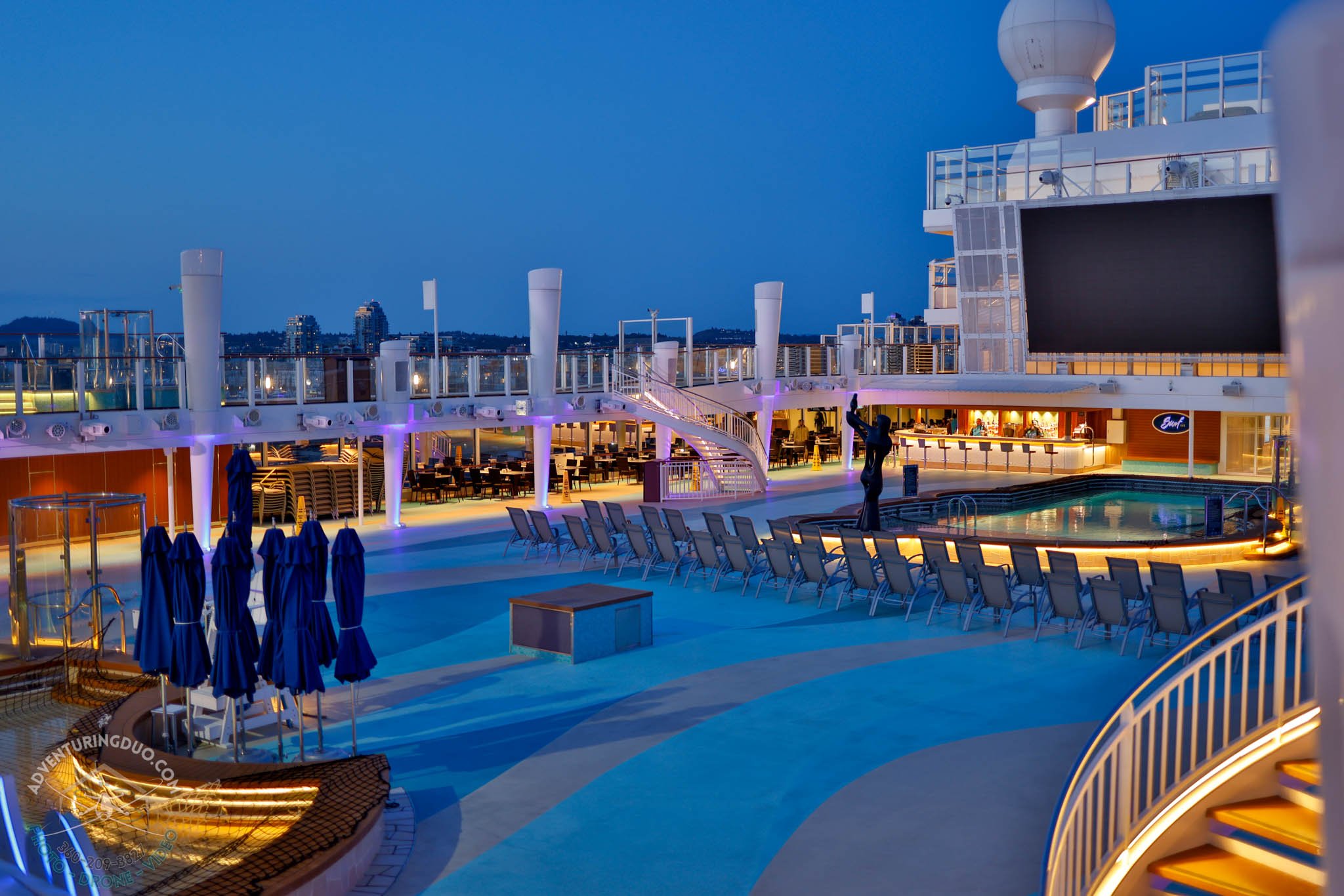 Pool deck on Norwegian Encore glowing at blue hour
Evening photography of the Encore’s central pool and lounge area, showing off architectural lighting and serene ambience—perfect for cruise marketing or editorial use.