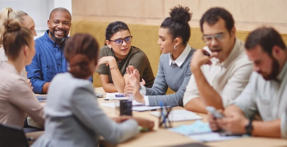 Coworkers clustered around a table