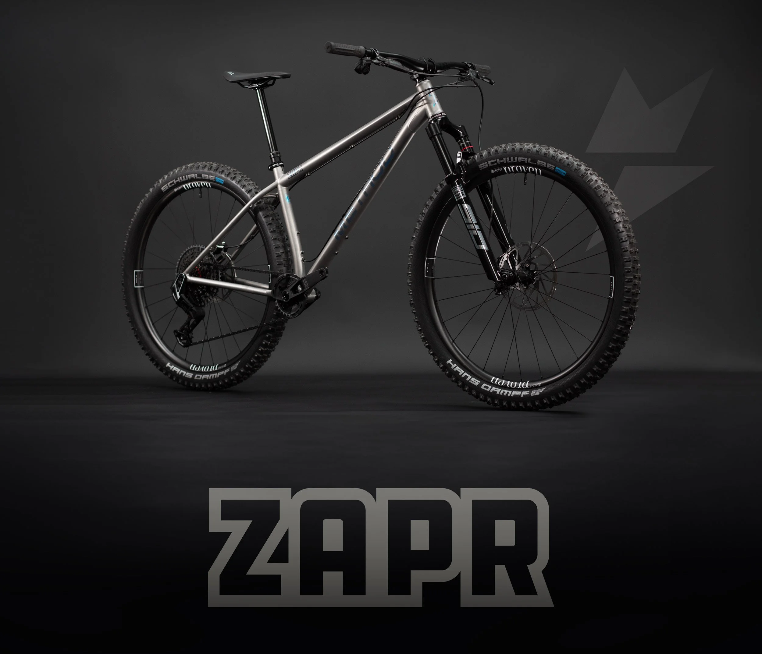 A Method Frameworks Zapr titanium mountain bike studio lit photograph of the complete bicycle on a black background.