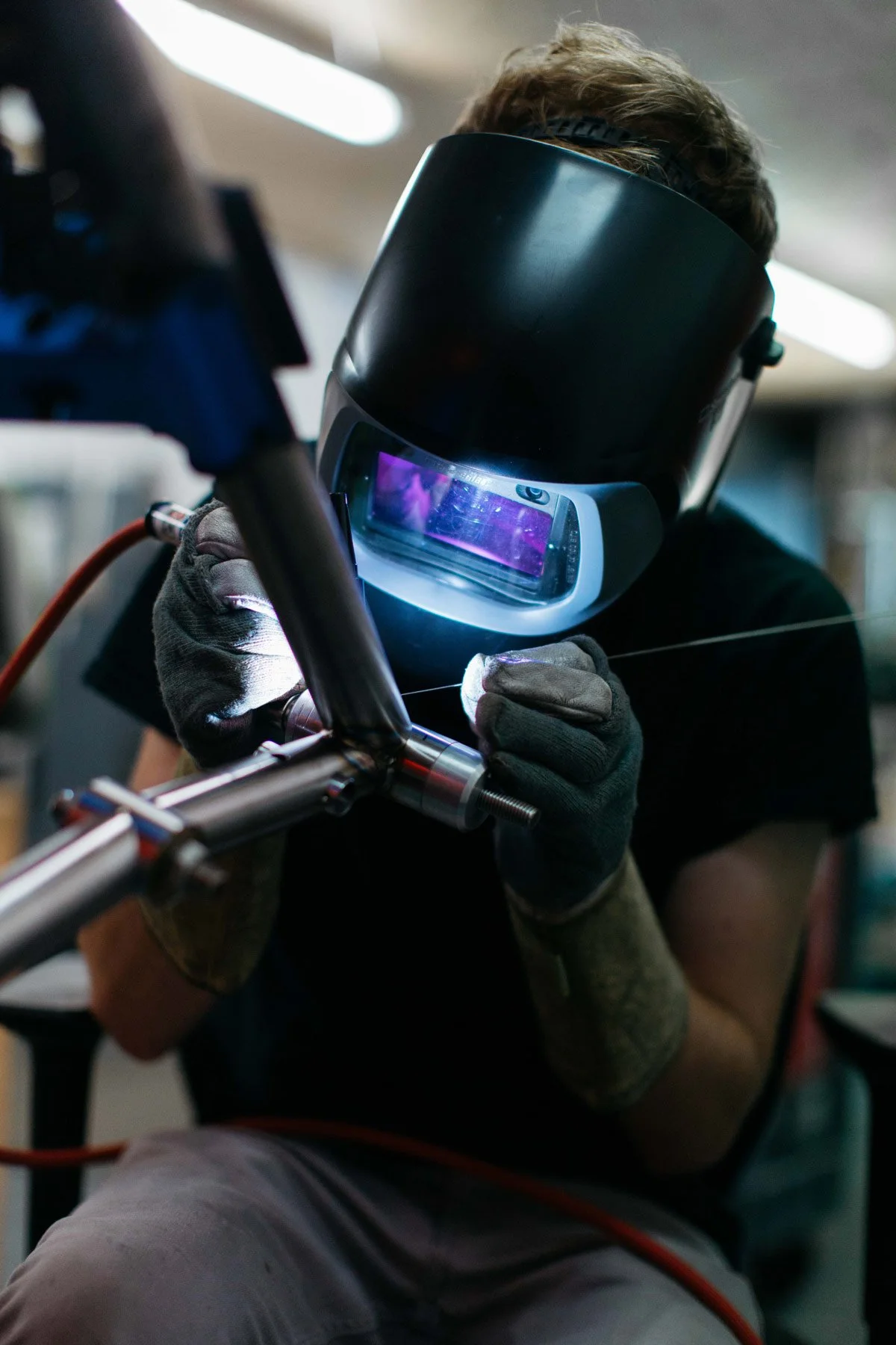 A close up of a Method Frameworks fabricator TIG welding a steel bicycle frame.
