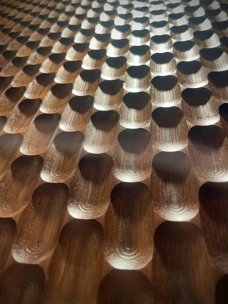 Close-up of metallic engraved surface with repeating rounded patterns.