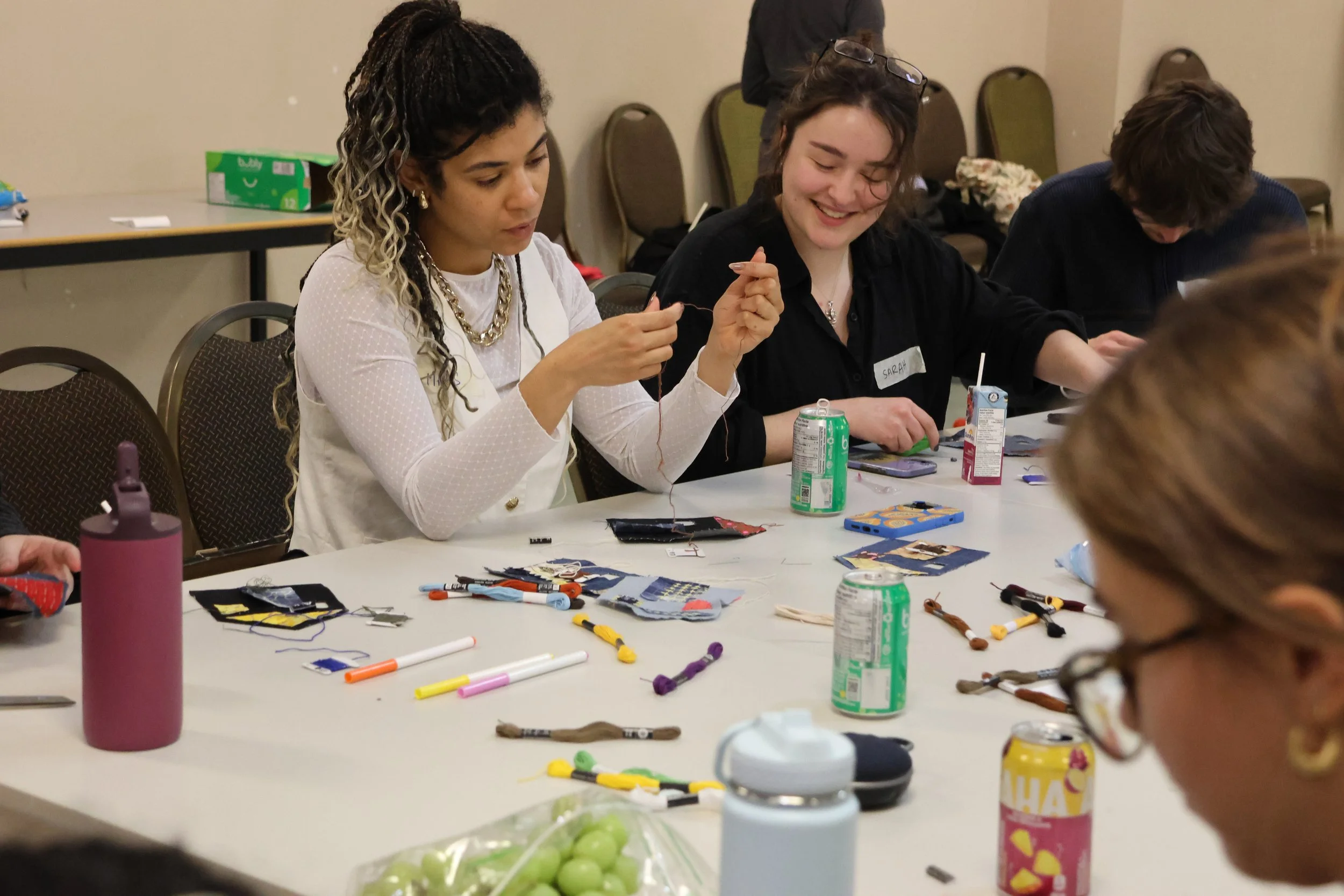 Participants learning basic mending techniques such as a running skitch, sashiko, and darning on prepared house materials made from upcycled fabric.