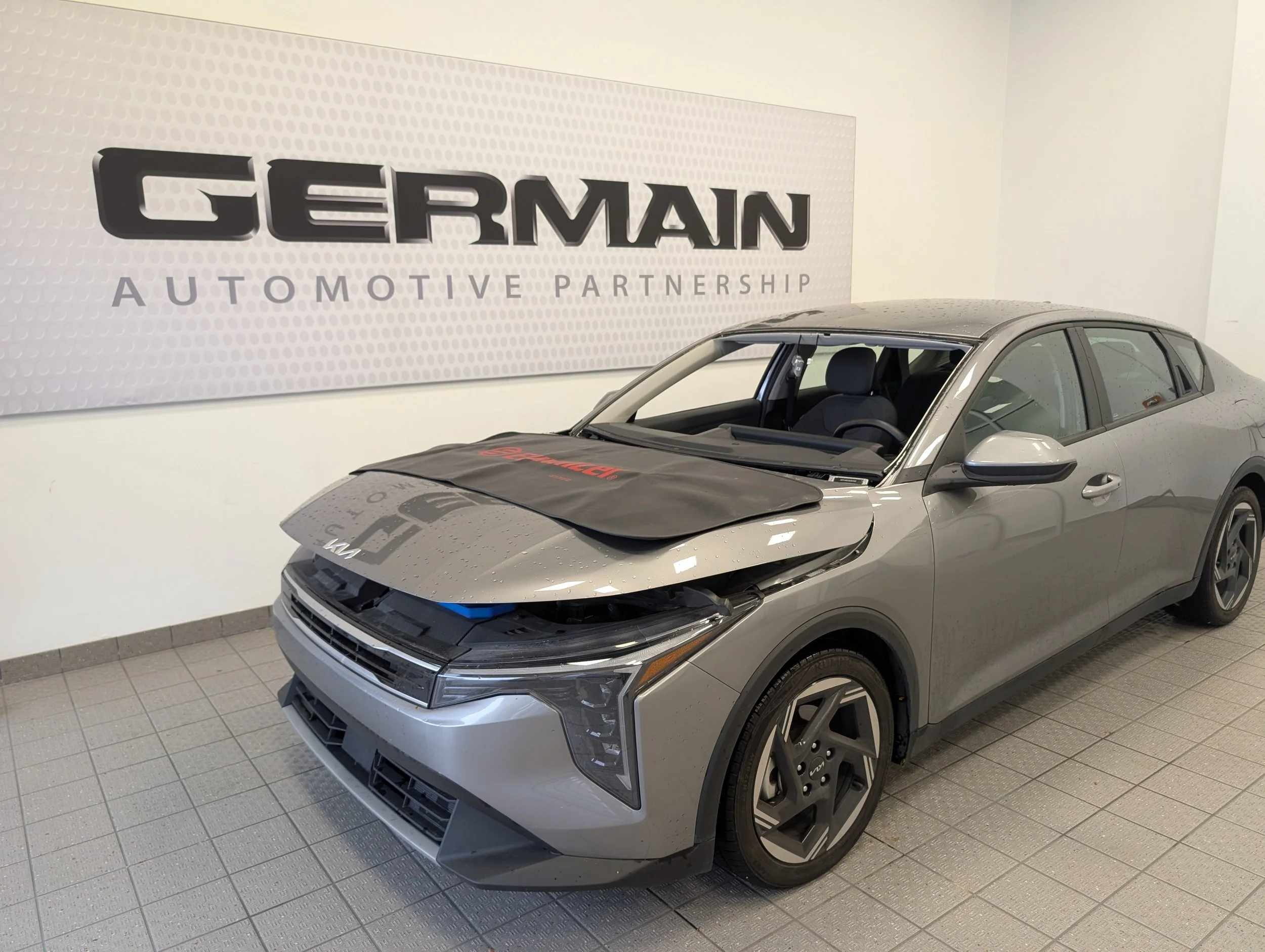 A new Kia with its' windshield removed at the dealership