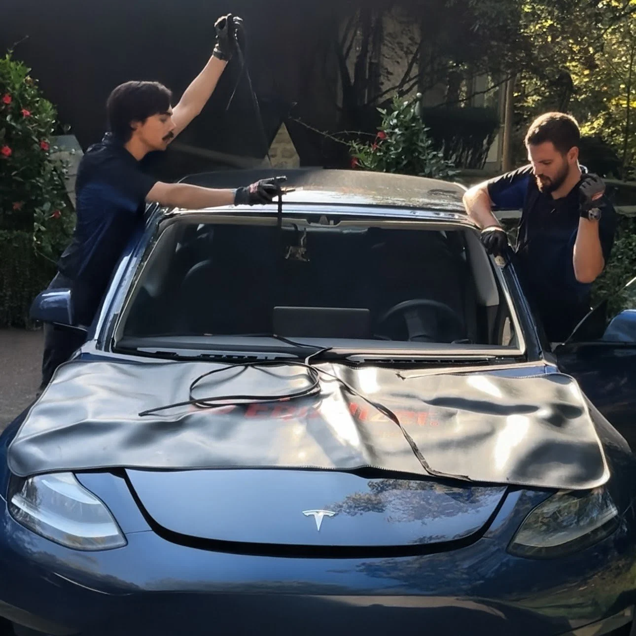 Someone shooting glue for a new windshield on the body of a car