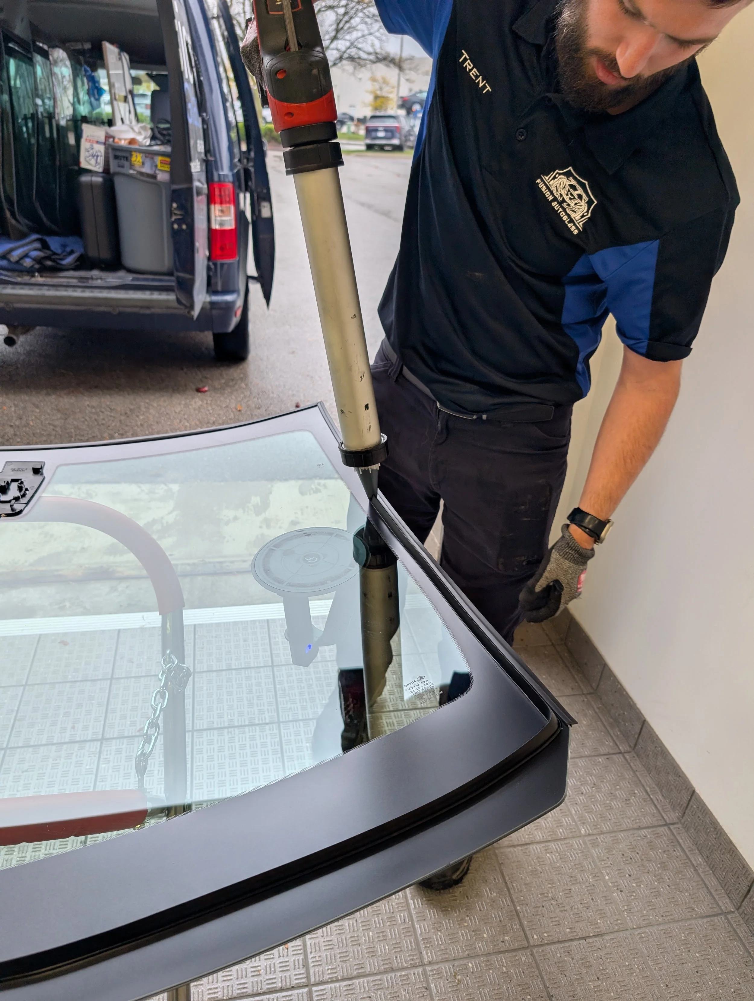 Technician Trent shooting urethane onto the glass