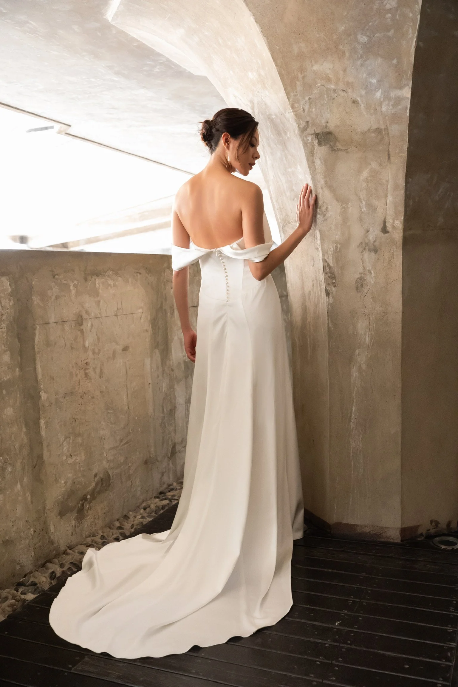 Celine-brudekjolen set bagfra med drapering omkring skuldrene og en elegant, tætsiddende silhuet