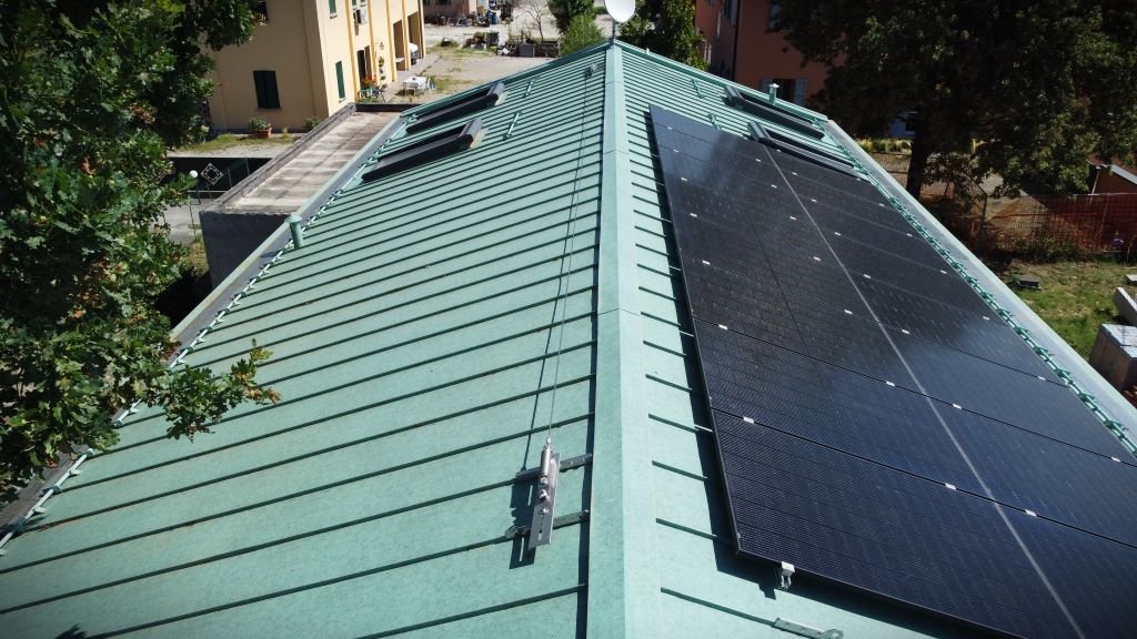 Tetto di un edificio con pannelli solari installati su una parte della superficie e lucernari.