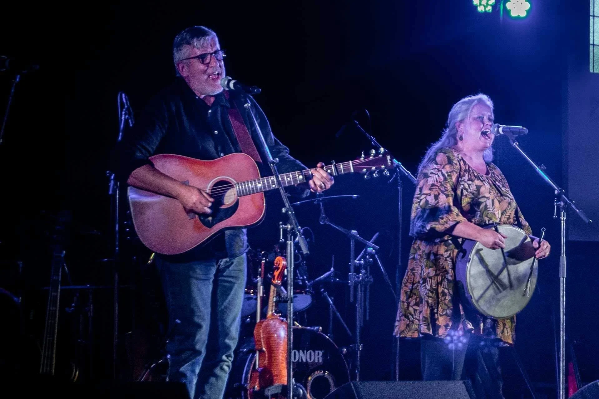 man with guitar and woman with bodhran both are singing
