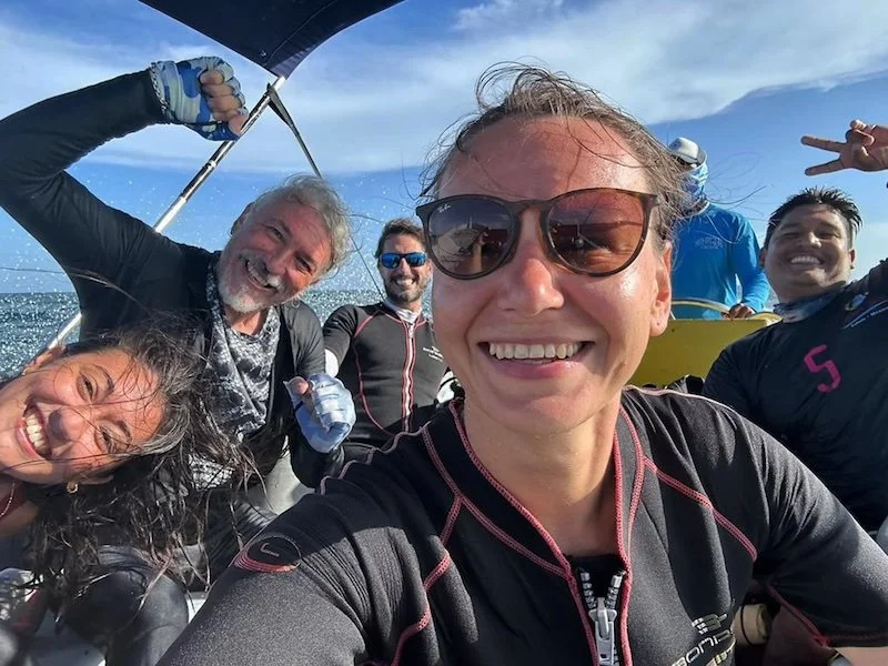 Group of divers sitting on a boat smilling after a nice dive day on the sea in tulum mexico