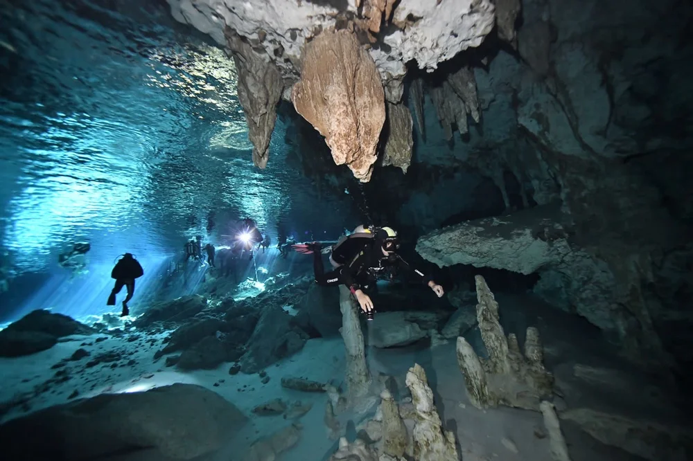 Scuba diver inside Dos Ojos cenote cavern in Tulum