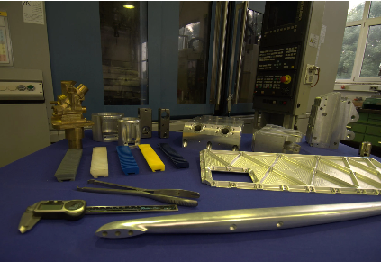 Verschiedene Metallteile und Werkzeuge auf einem blauen Tisch in einem Labor oder Werkstatt