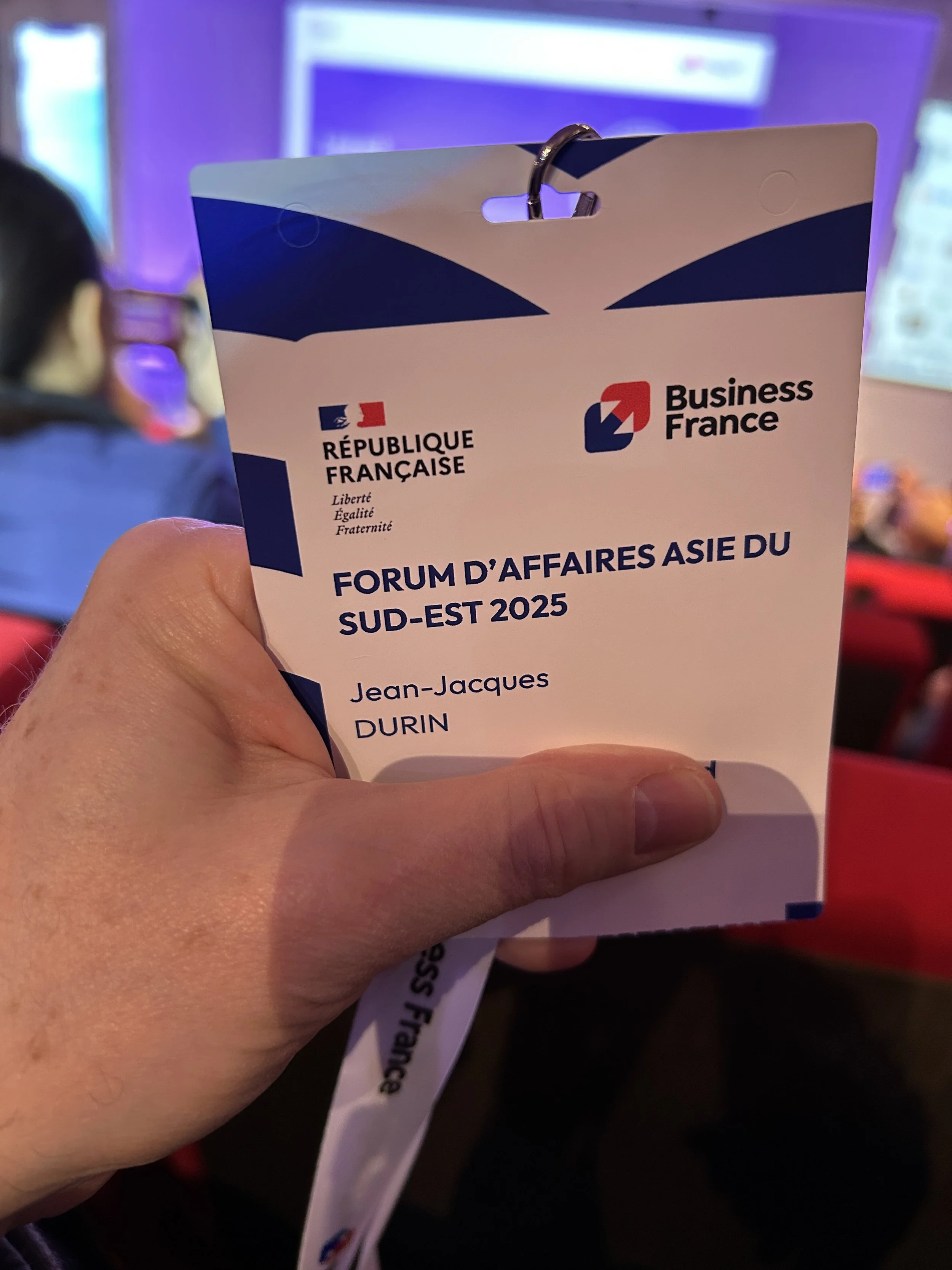Badge d'un participant au 'Forum d'Affaires Asie du Sud-Est 2025' organisé par la République Française et Business France. Nom visible sur le badge.