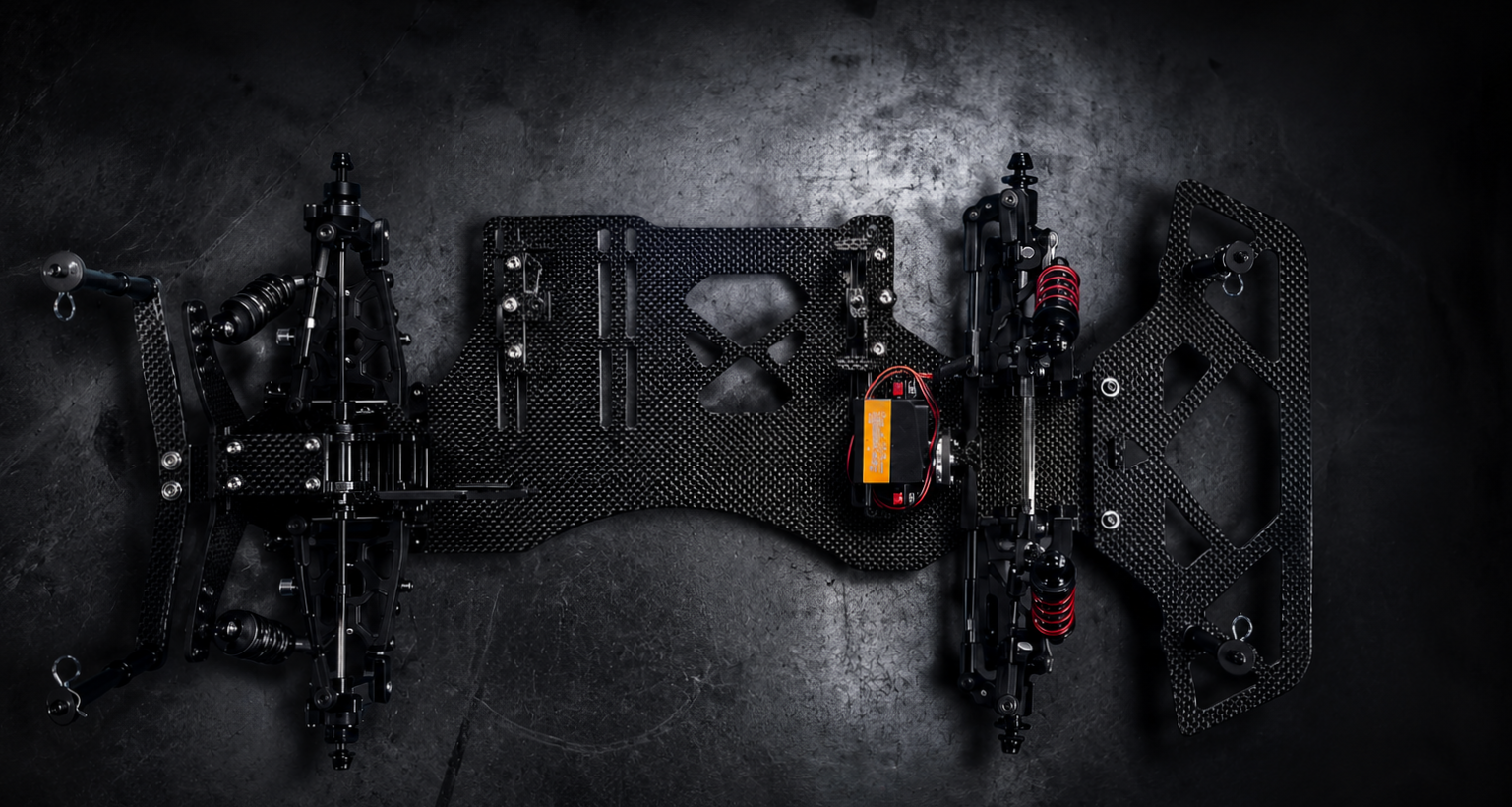 Top view of a partially assembled RC car chassis with electronic components and suspension system.