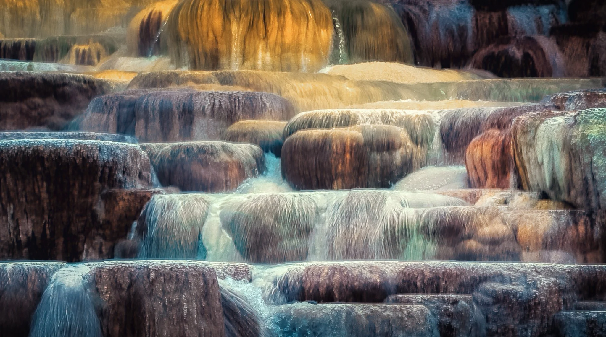 Detailed abstract view of cascading travertine terraces and mineral deposits at Mammoth Hot Springs in Yellowstone National Park.