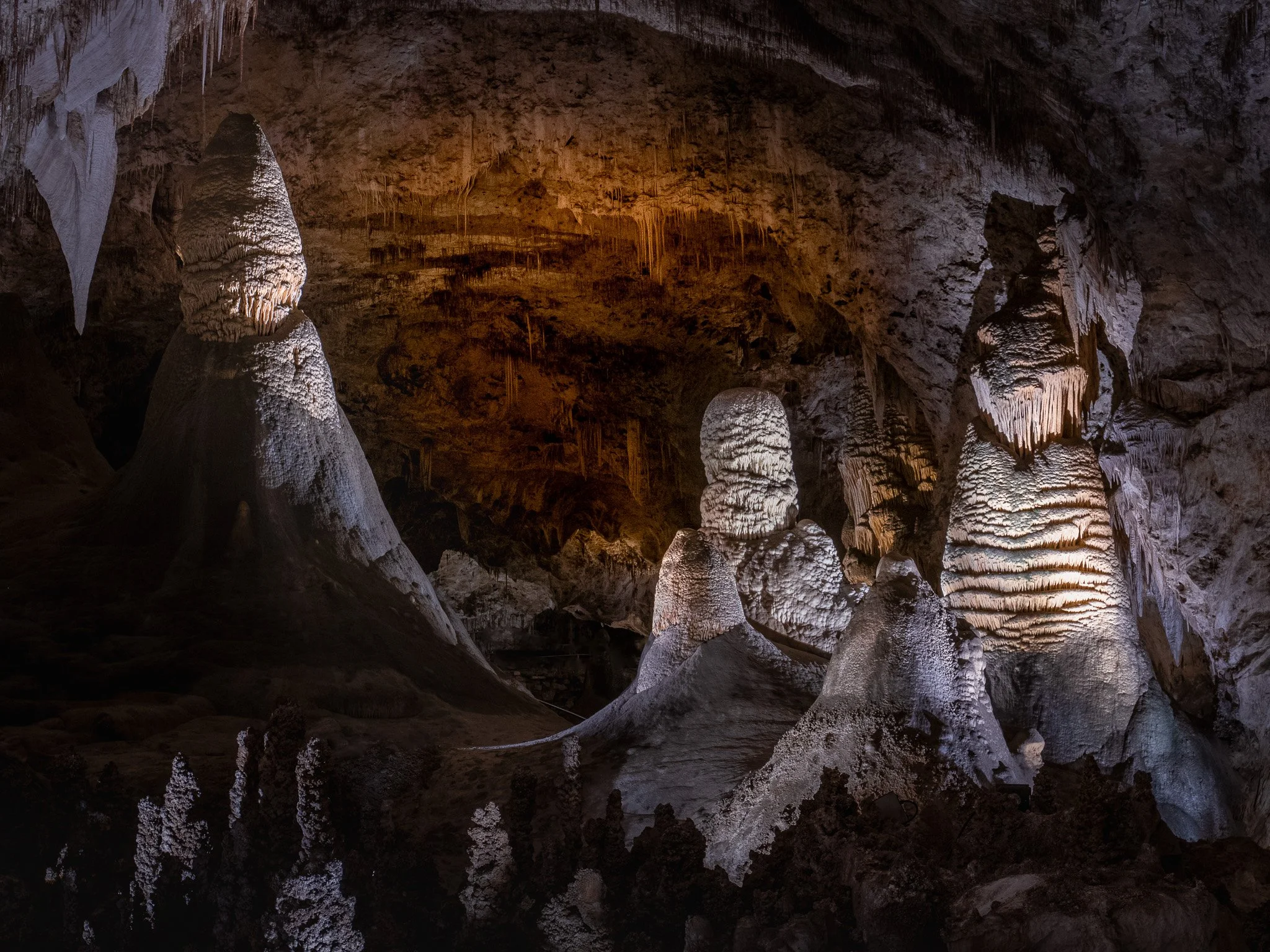 Illuminated stalagmites and limestone formations inside the subterranean Big Room at Carlsbad Caverns National Park.