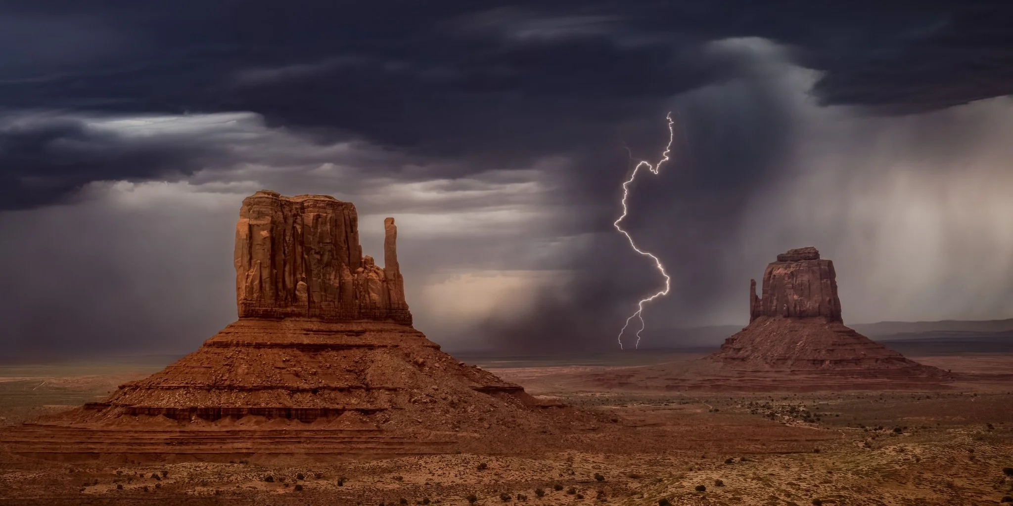 Epic image of perfectly timed and placed lightening strike in monument valley, Utah resulting from an august monsoon