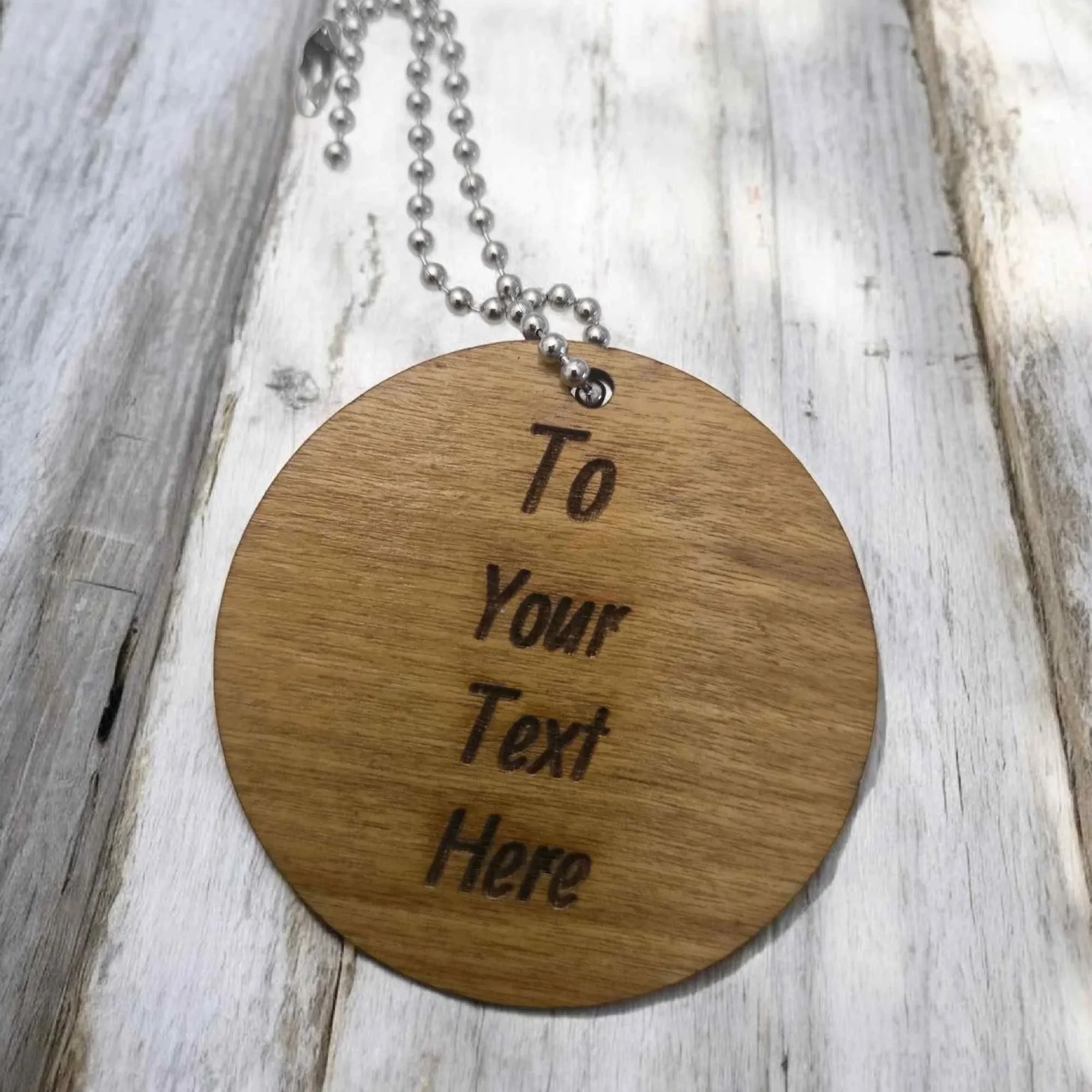 Custom laser-engraved round wooden tag for a personalised sports gift set.