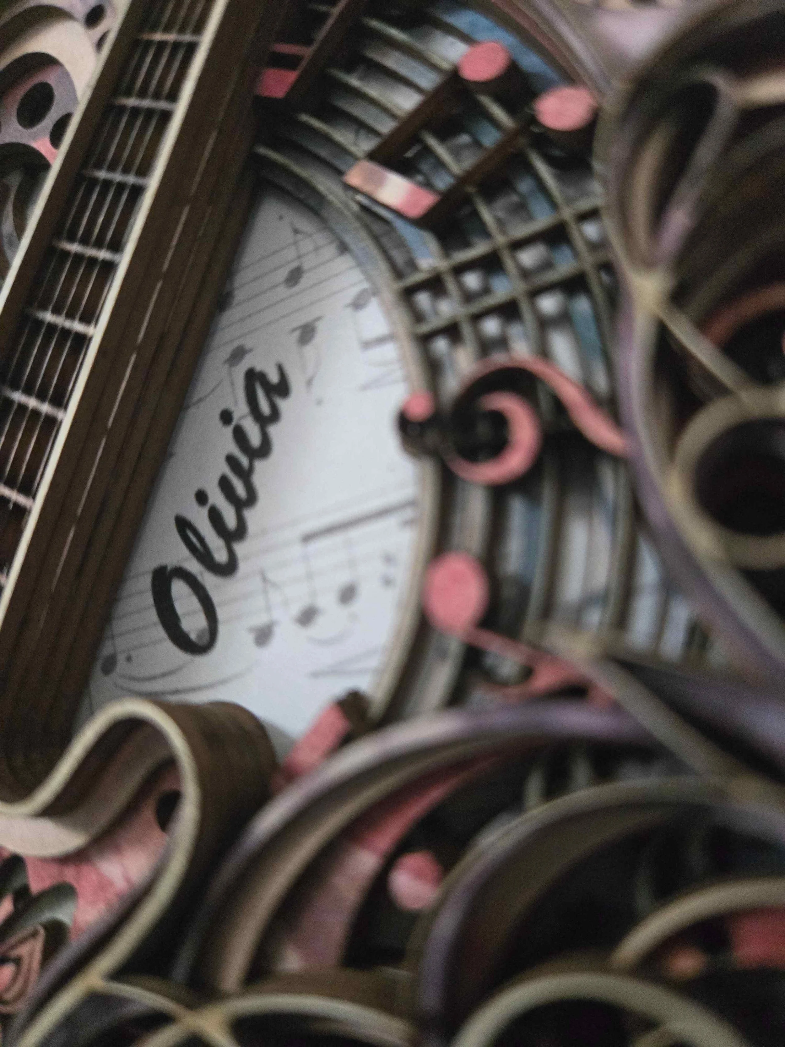 Close-up of the custom name and ribbon on a handmade guitar card.