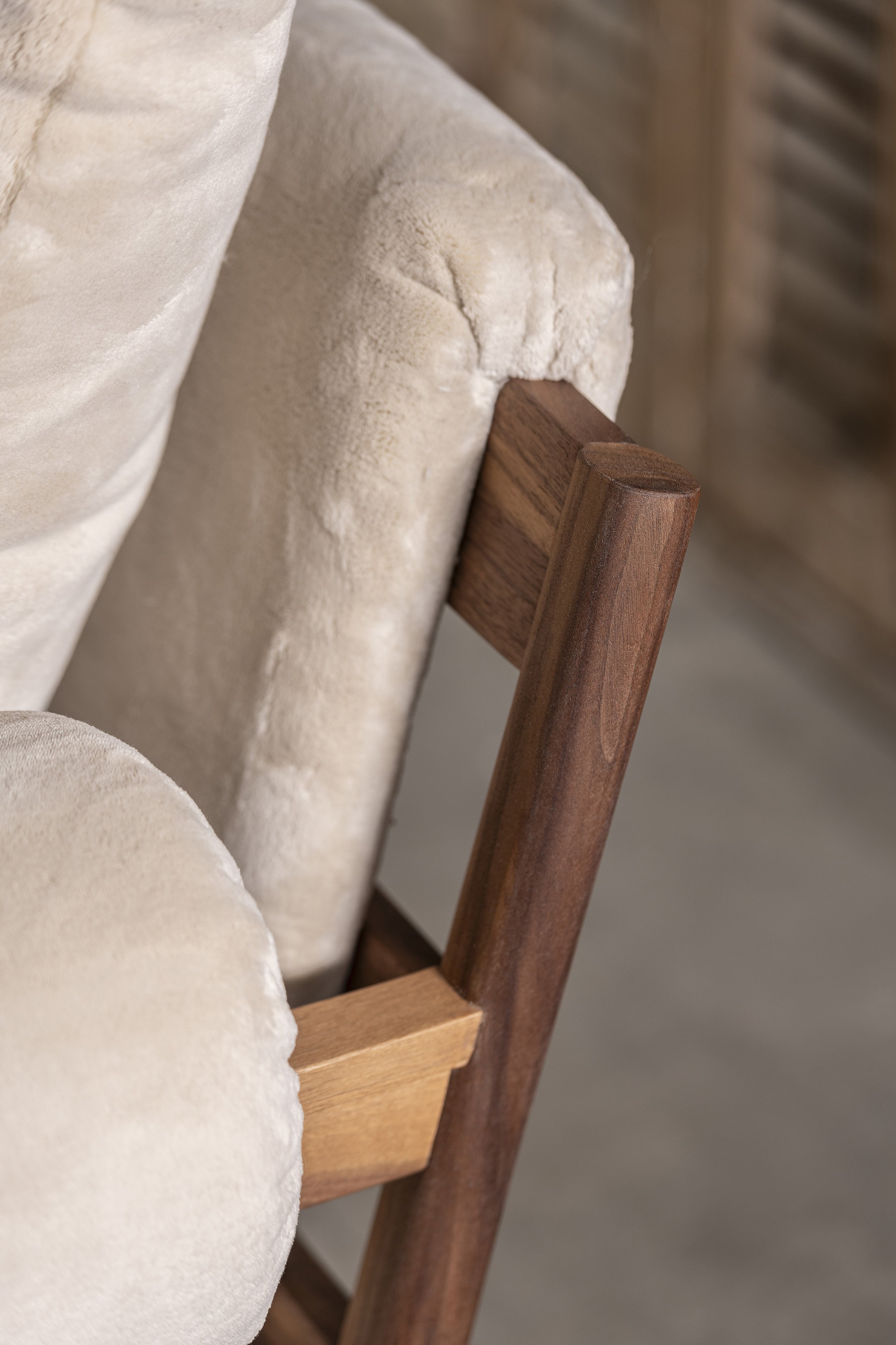 An image of a detail from a lush armchair made from American walnut with made to measure upholstery.