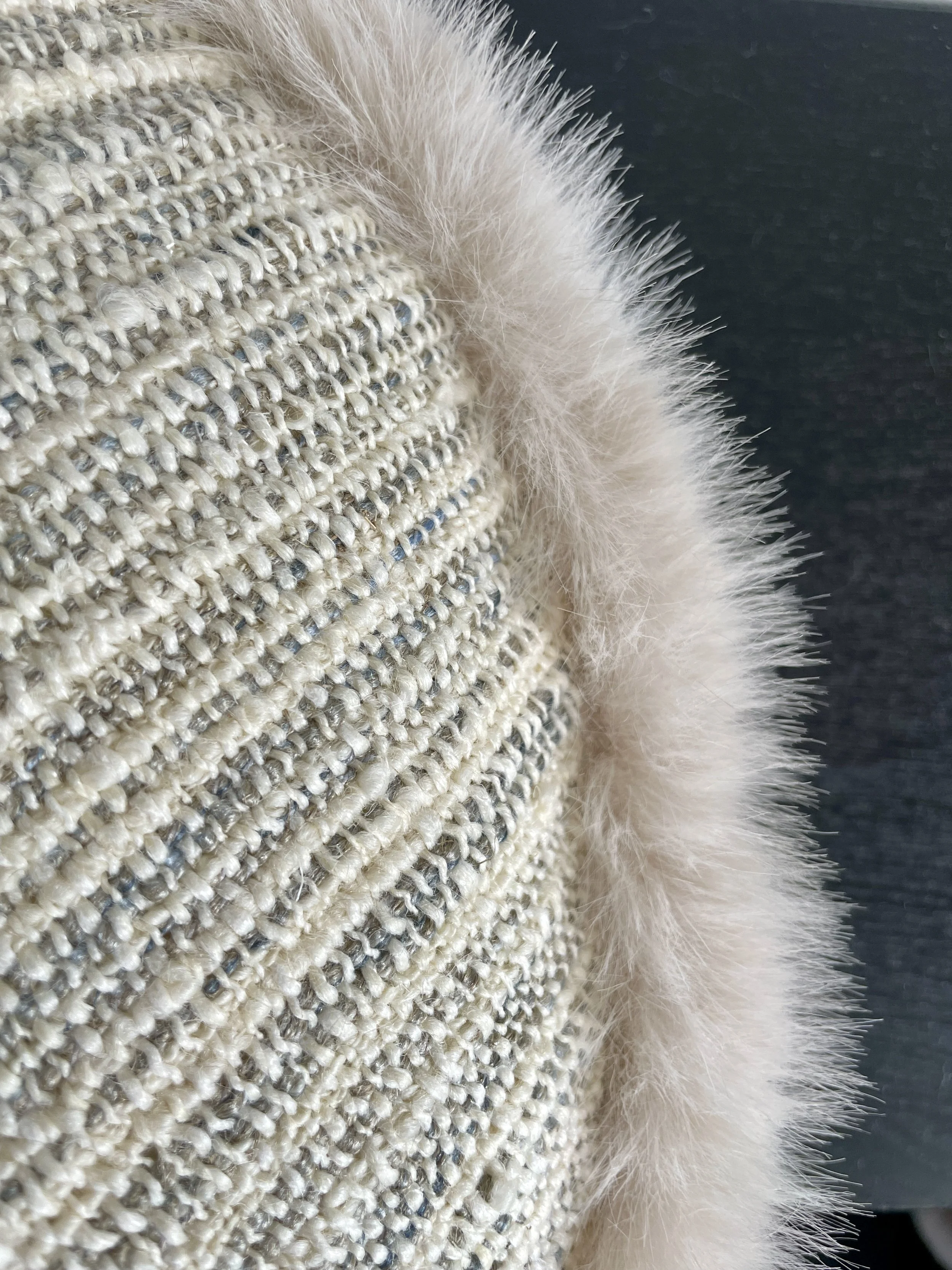 An image of a round cushion cover with faux fur border.