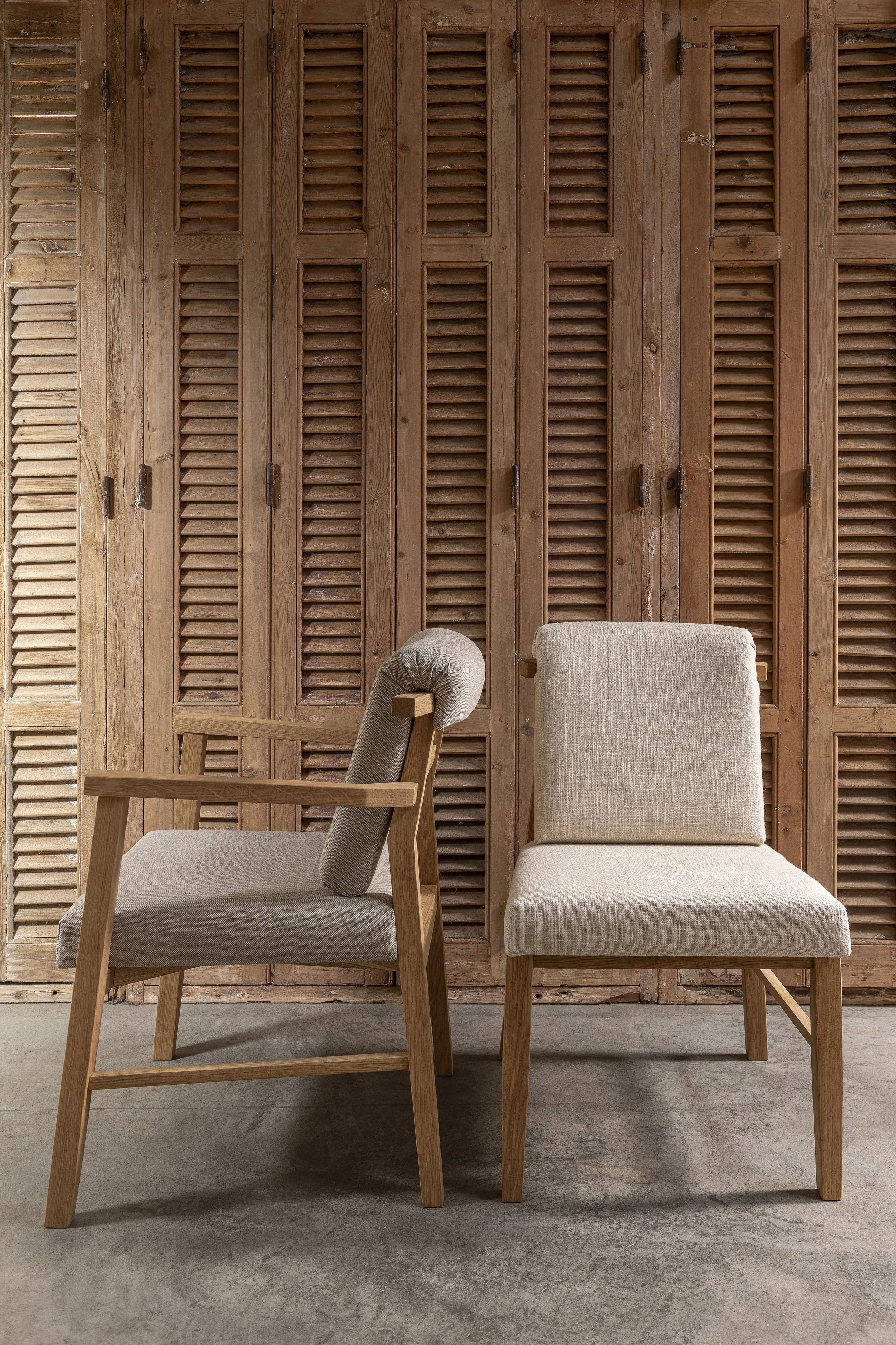 An image of 2 dining chairs side by side, one with armrest and the other without.
