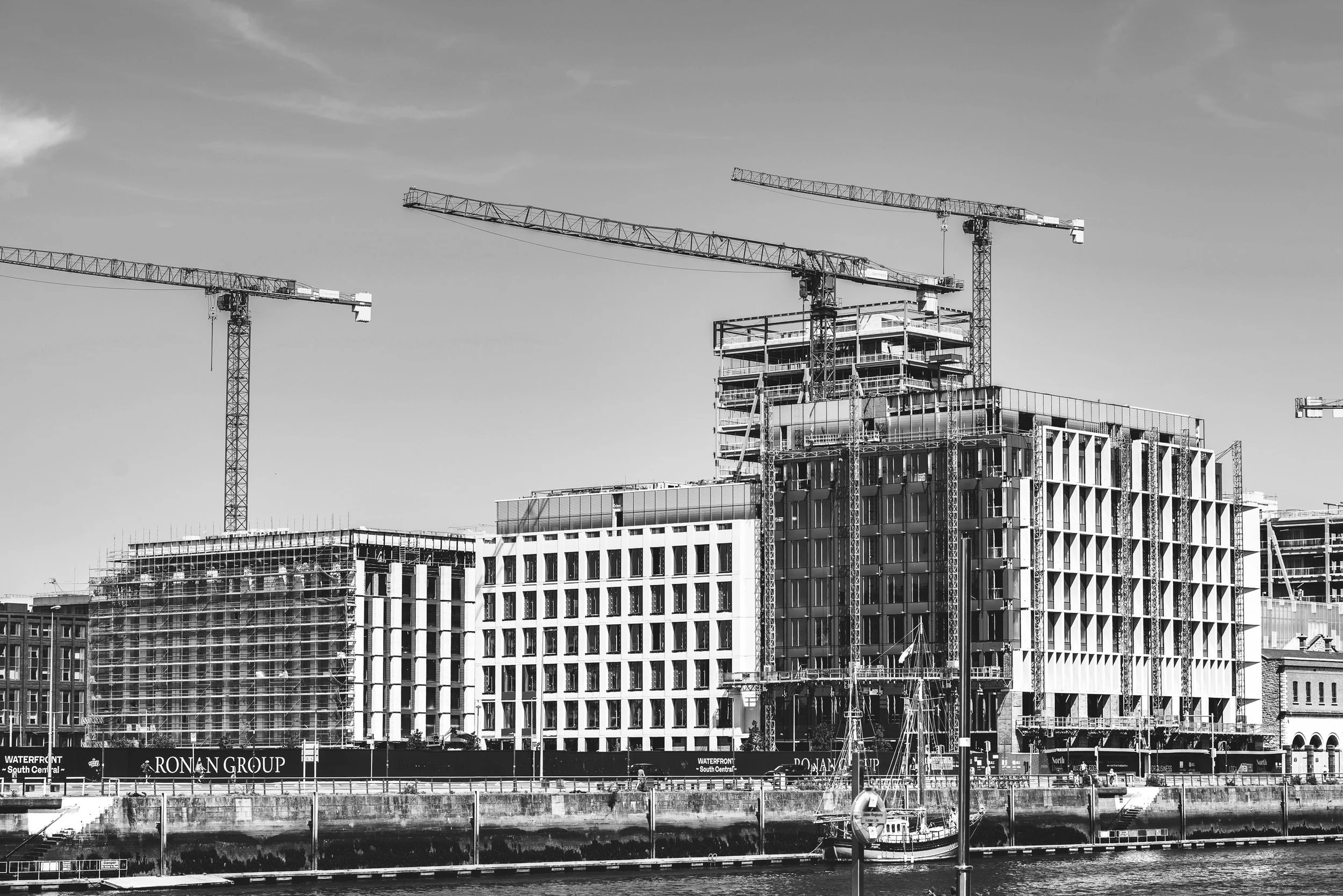 Plac budowy w Dublinie z żurawiami i powstającą współczesną zabudową miejską.