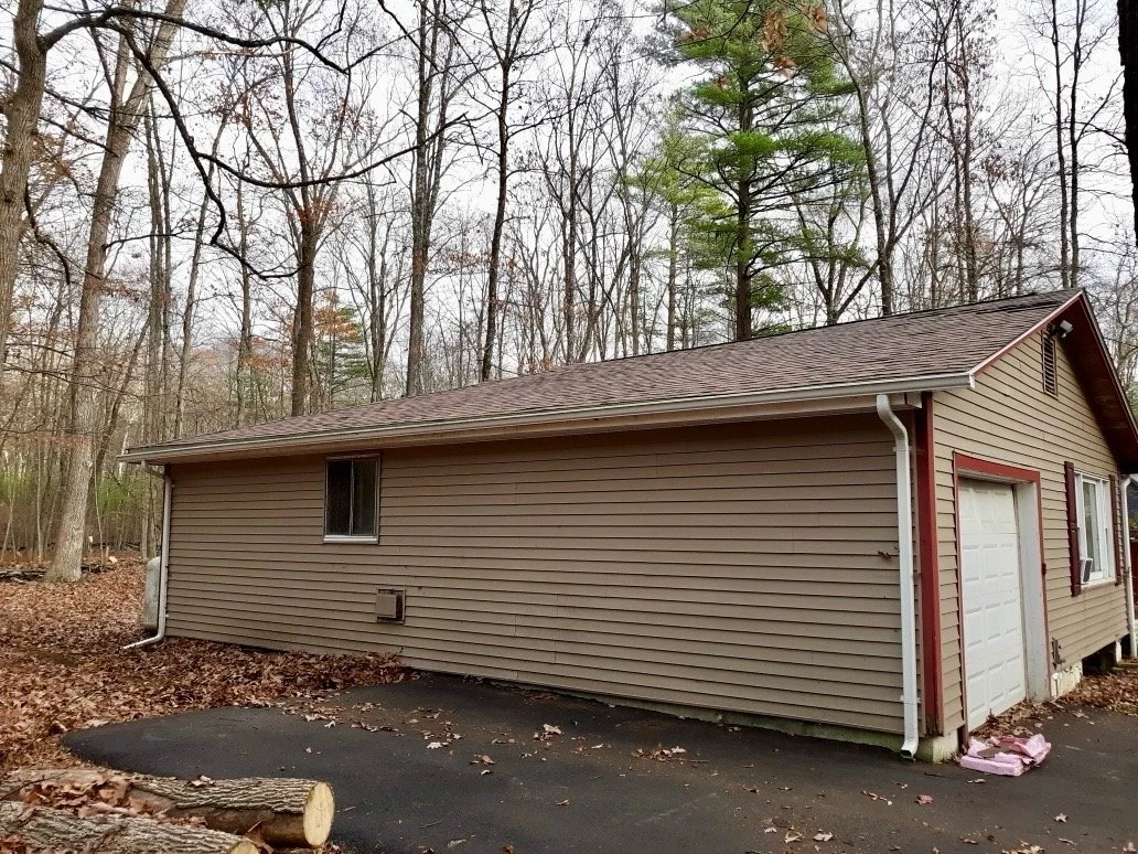 Back of a beige house. New Siding & shingle roof in Hawley, PA.