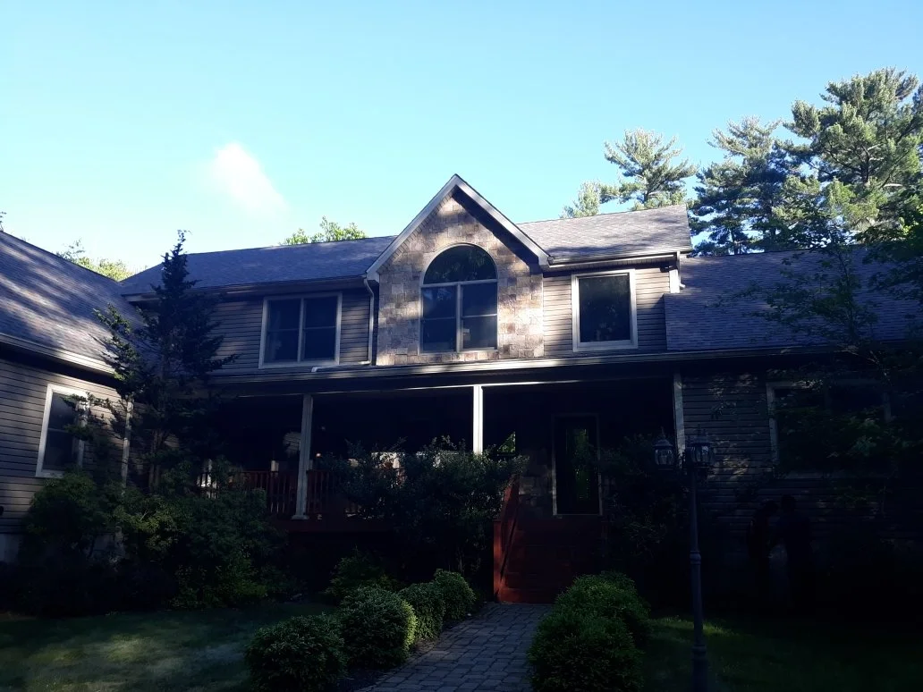 Front view of a two-story house with a porch, with a new roof in Milford PA.