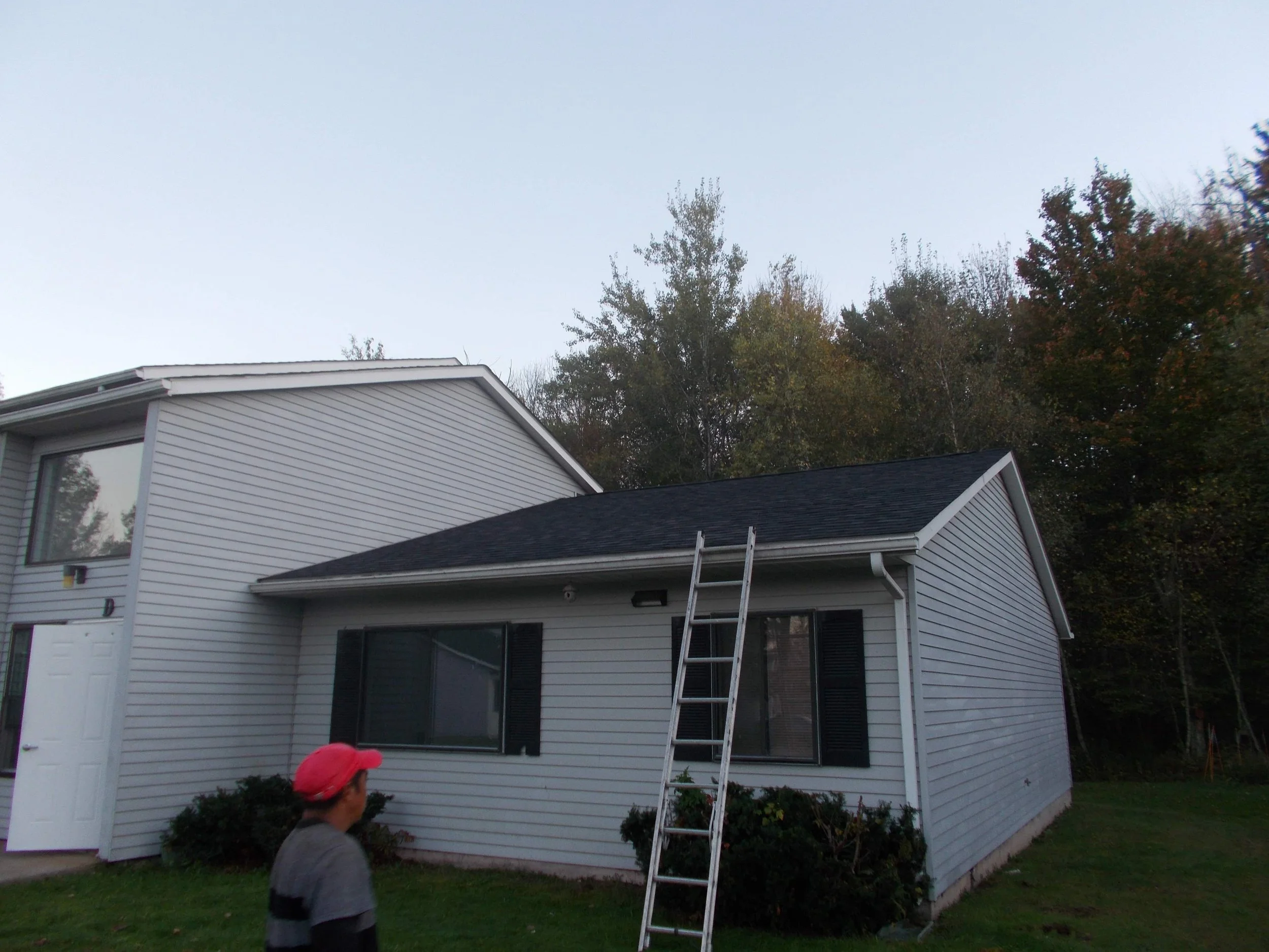 A two-story white house with black shutters. New Roof & Siding in Milford PA.