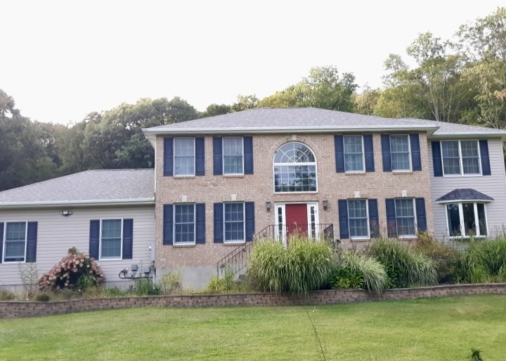 Large two-story house with NEW siding exterior, multiple windows with shutters, and a NEW roof in Milford PA.