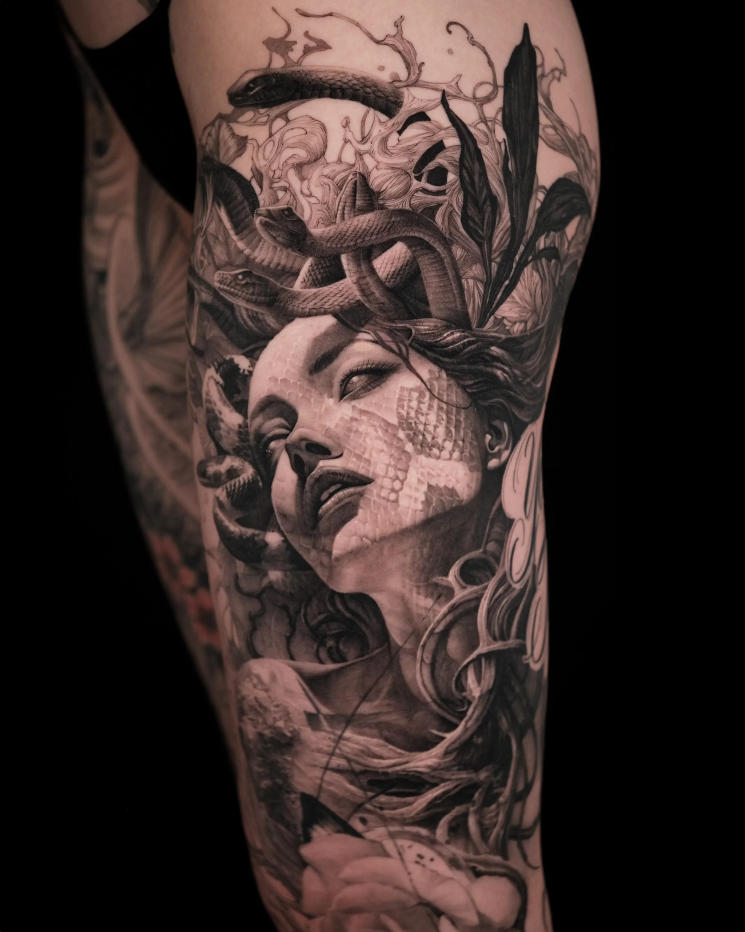 Intricate tattoo of a Medusa-like figure with snakes as hair, detailed shading and patterns on skin