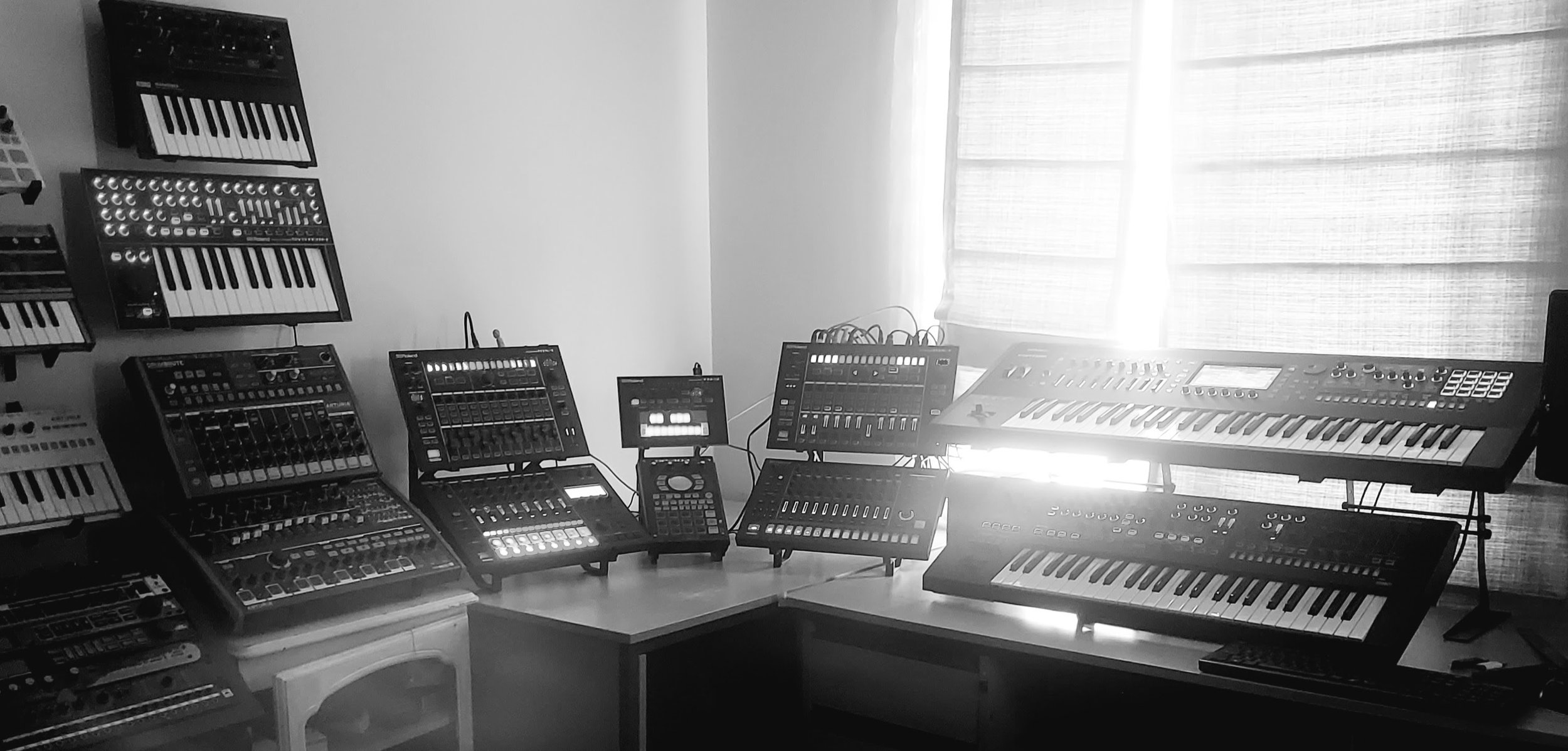 Professional electronic music studio setup featuring desktop synth stands, tiered workflow systems and modular equipment by Studio Solutions