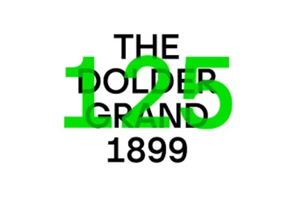 Text reading 'The Doer Grand 1899' with 'Doer' and '1899' in green and larger, other words in black.