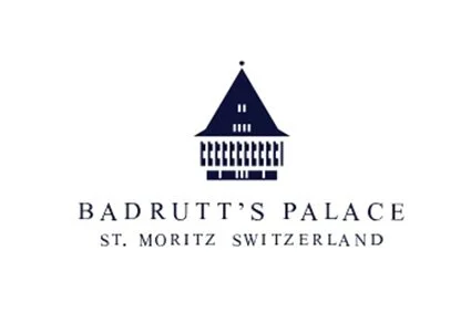 Logo for Badrutt's Palace in St. Moritz, Switzerland, featuring a stylized blue building with a pointed roof.