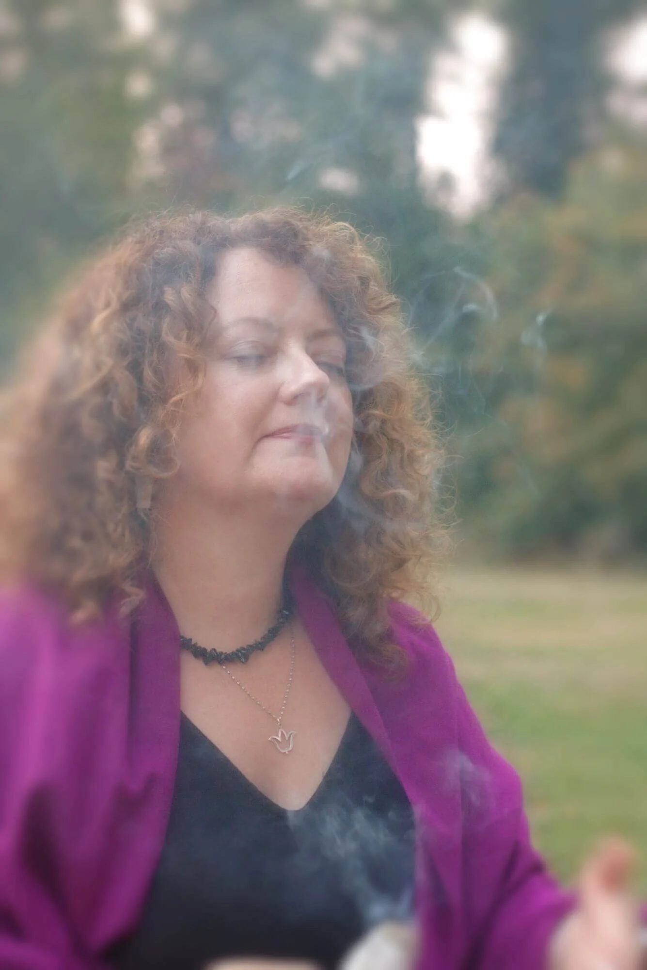 Sarah Blue Cloud participating in a spiritual cleansing ritual with sage, surrounded by smoke during a ceremony in Portland.