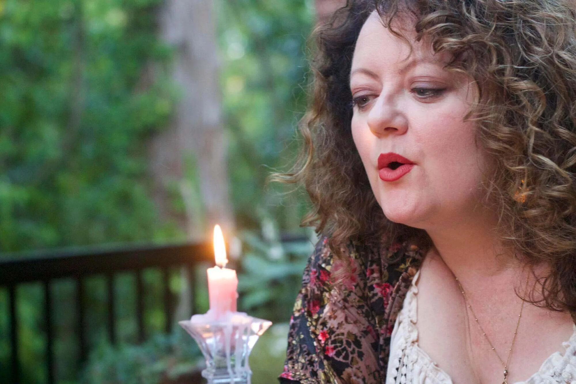 Sarah Blue Cloud gently blowing out a candle during a spiritual house blessing ritual in Portland, Oregon.